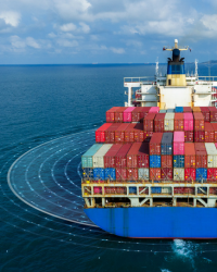 Stacked multicolored shipping containers under a clear blue sky.