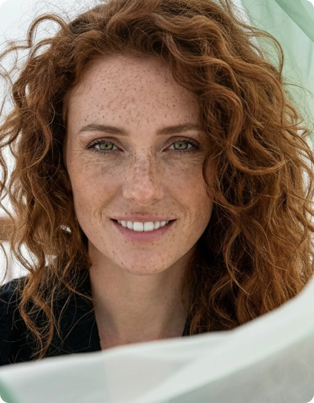 A woman with freckled hair is smiling for the camera.