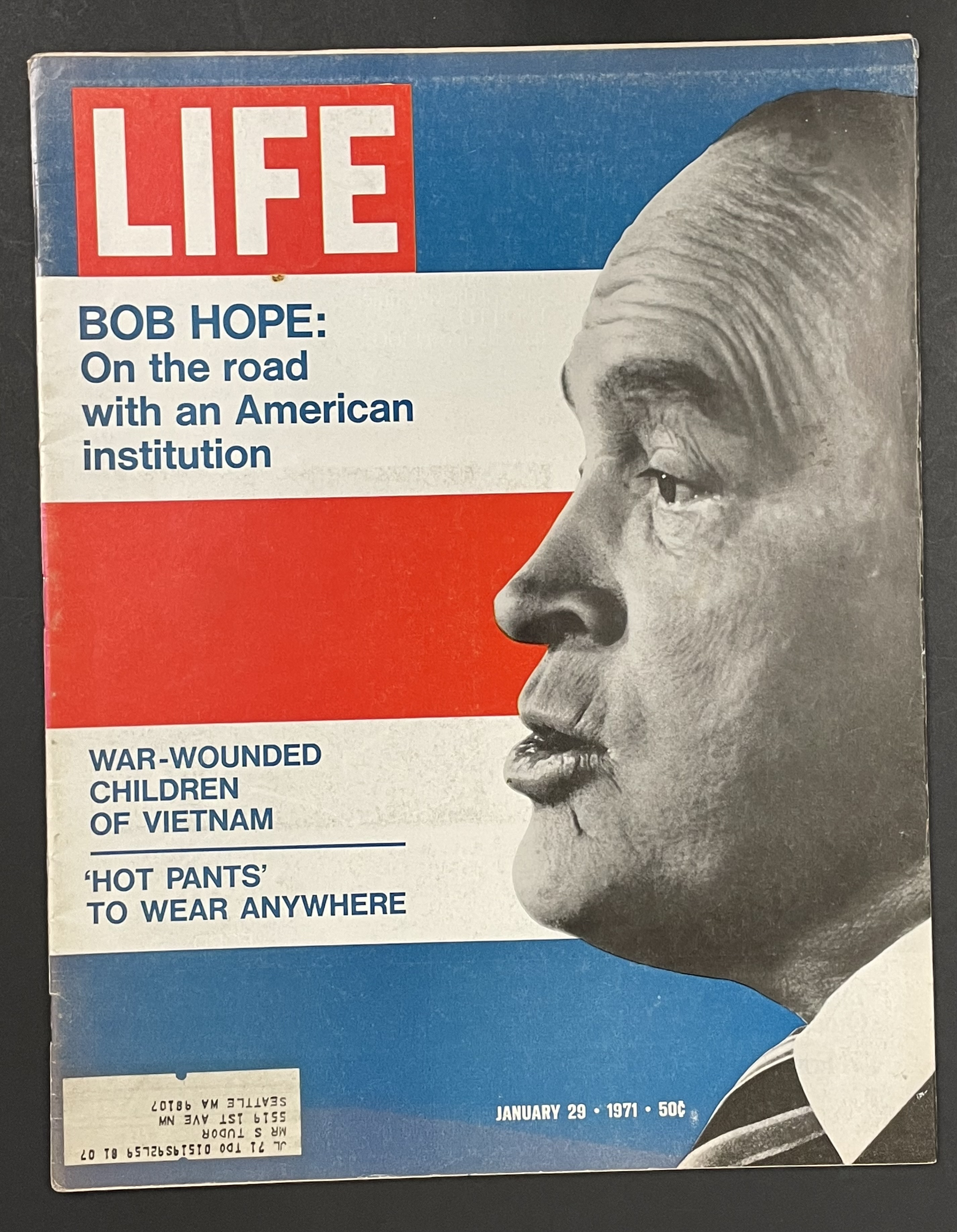 Costume sketch of a clown-like figure with a round beige torso, orange-striped sleeves, oversized purple pants, yellow gloves, and large yellow shoes.