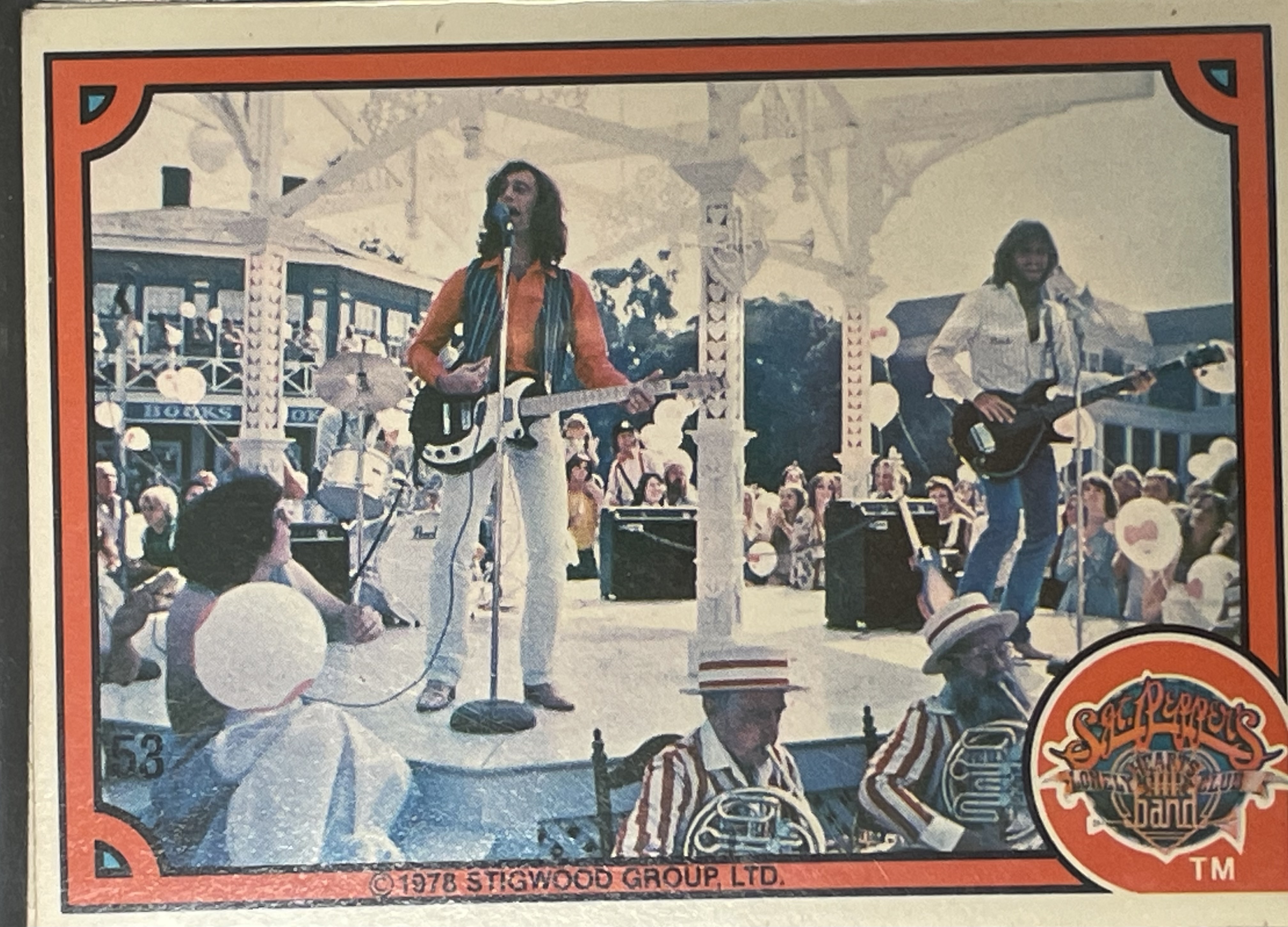 Costume sketch of a clown-like figure with a round beige torso, orange-striped sleeves, oversized purple pants, yellow gloves, and large yellow shoes.