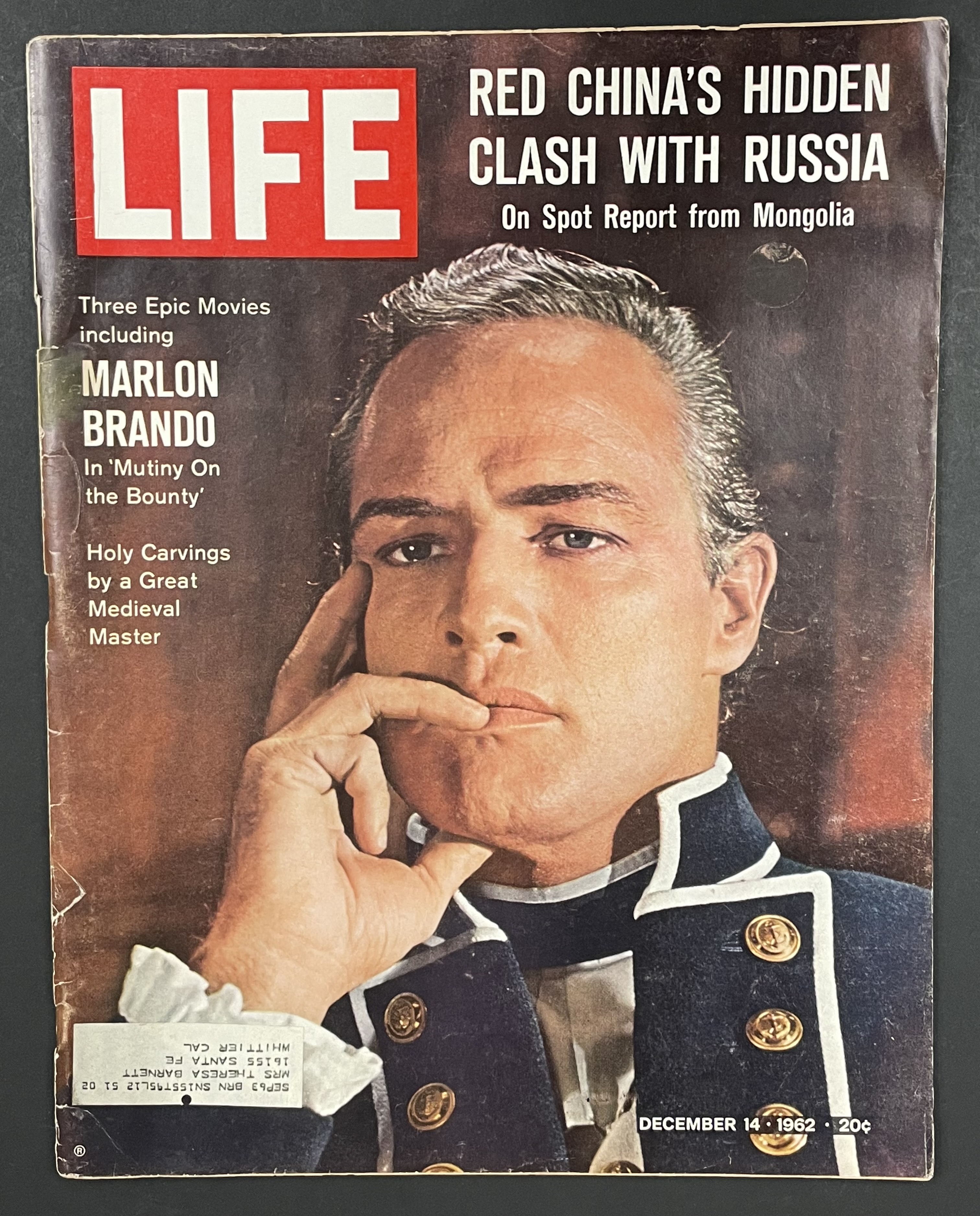 Costume sketch of a clown-like figure with a round beige torso, orange-striped sleeves, oversized purple pants, yellow gloves, and large yellow shoes.