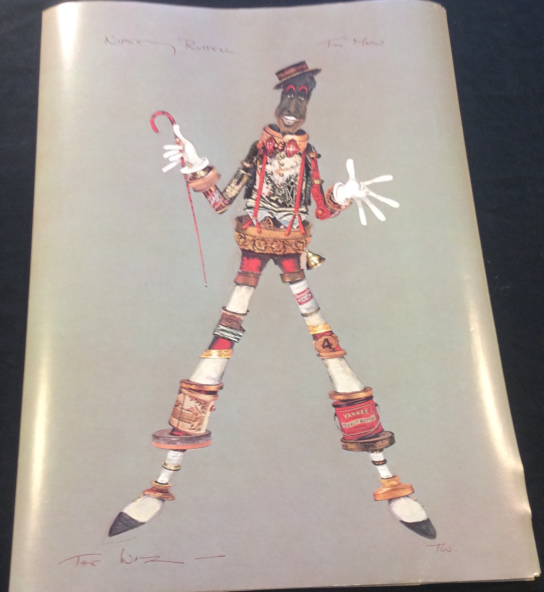 Costume sketch of a clown-like figure with a round beige torso, orange-striped sleeves, oversized purple pants, yellow gloves, and large yellow shoes.