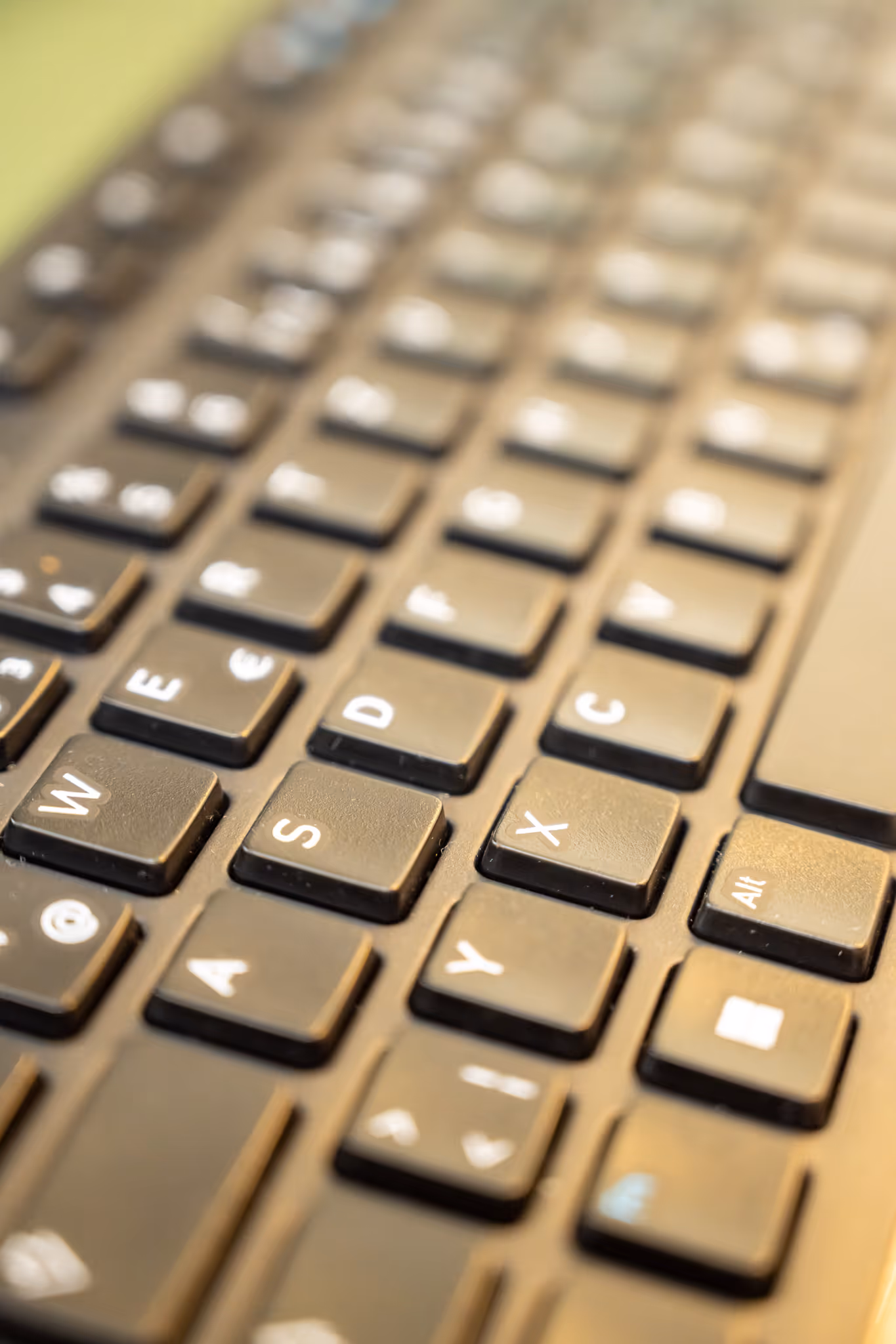 Nahaufnahme einer schwarzen Computertastatur mit unscharfen Tasten im Hintergrund.