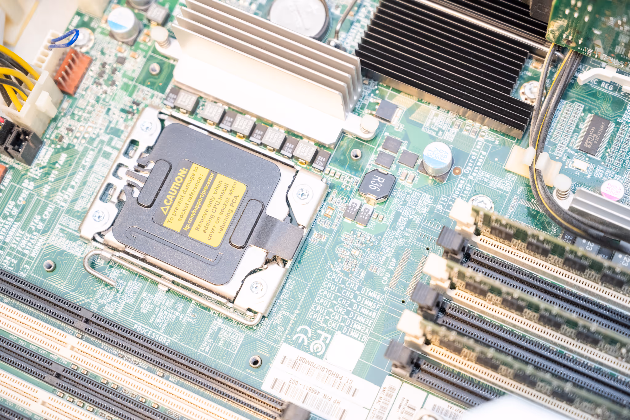 Nahaufnahme eines Computer-Motherboards mit installiertem CPU-Sockel und mehreren RAM-Modulen.