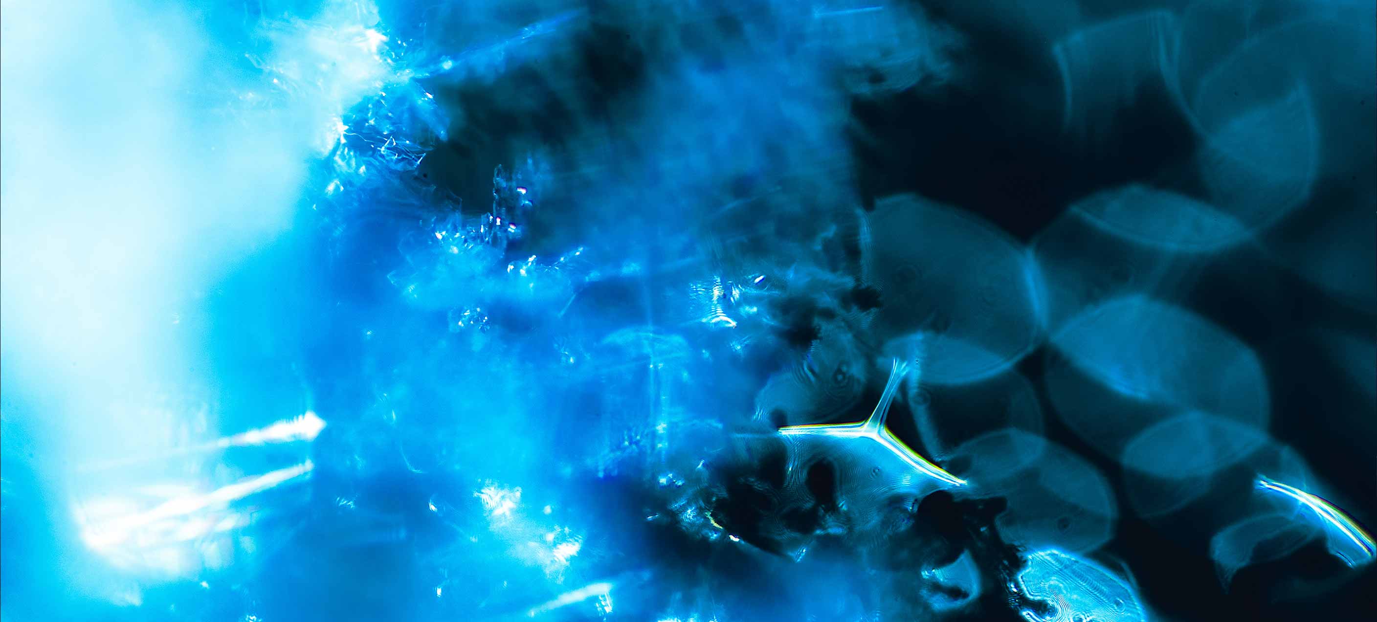 Stack of newspapers floating on clear, rippling water.