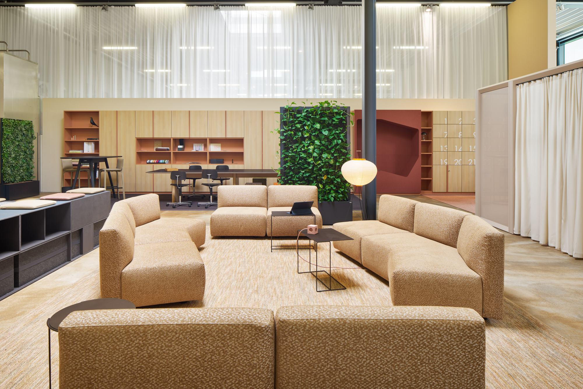 New Work Lab Nagold. Lounge mit Sitzmodulen, Pflanzenwand und Meeting-Bereich.