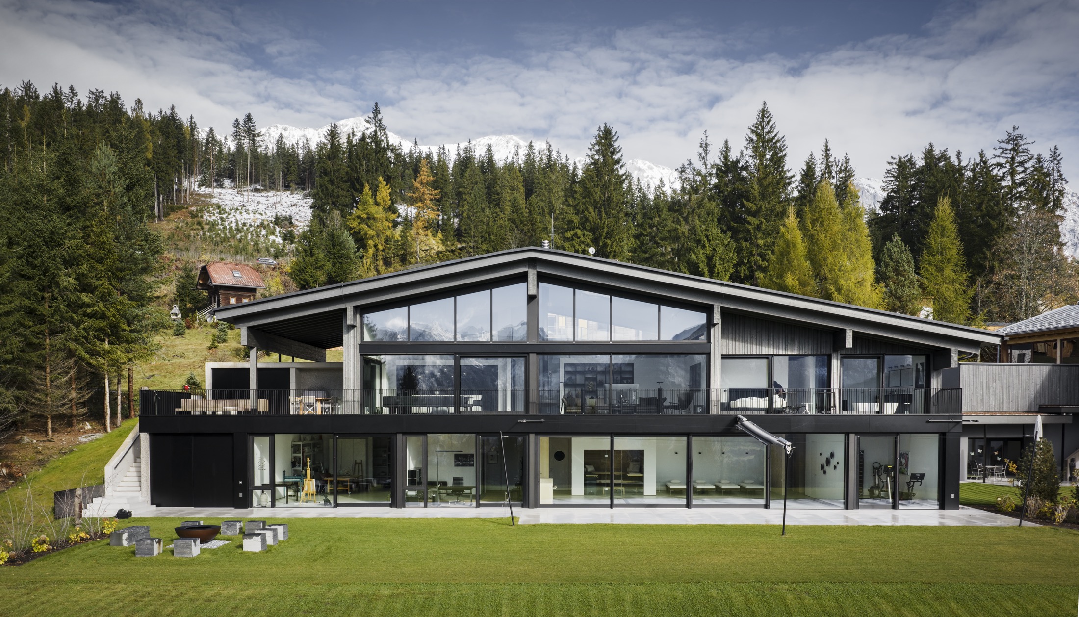 Wohnhaus in der Obersteiermark mit verglaster Fassade vor dem Bergpanorama