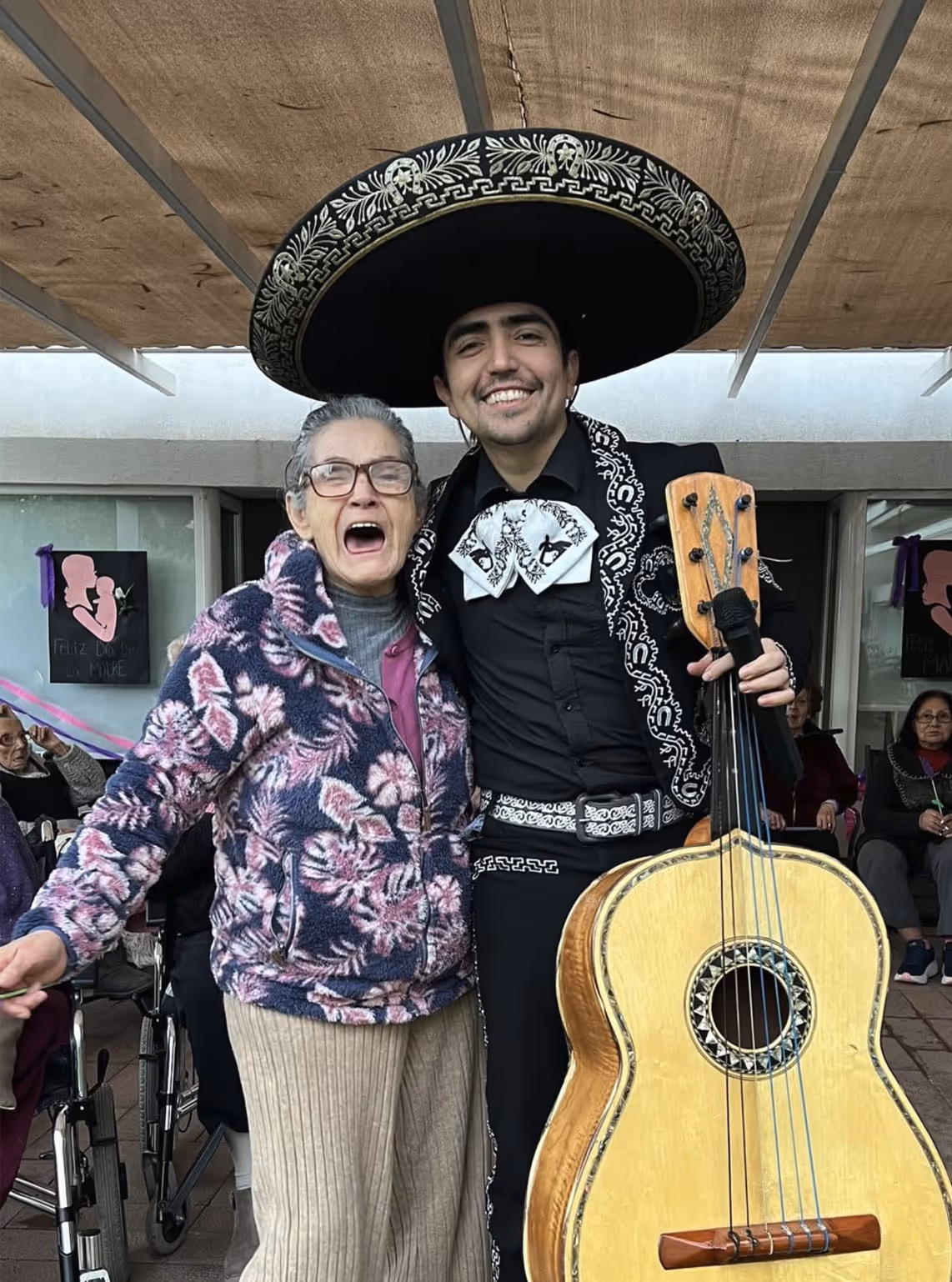 Dos mujeres sonrientes sentadas en un sofá mirando un álbum de fotos.