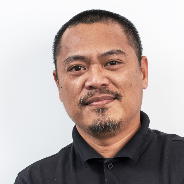 Portrait of a middle-aged man with short black hair, a mustache, and a goatee wearing a black collared shirt.