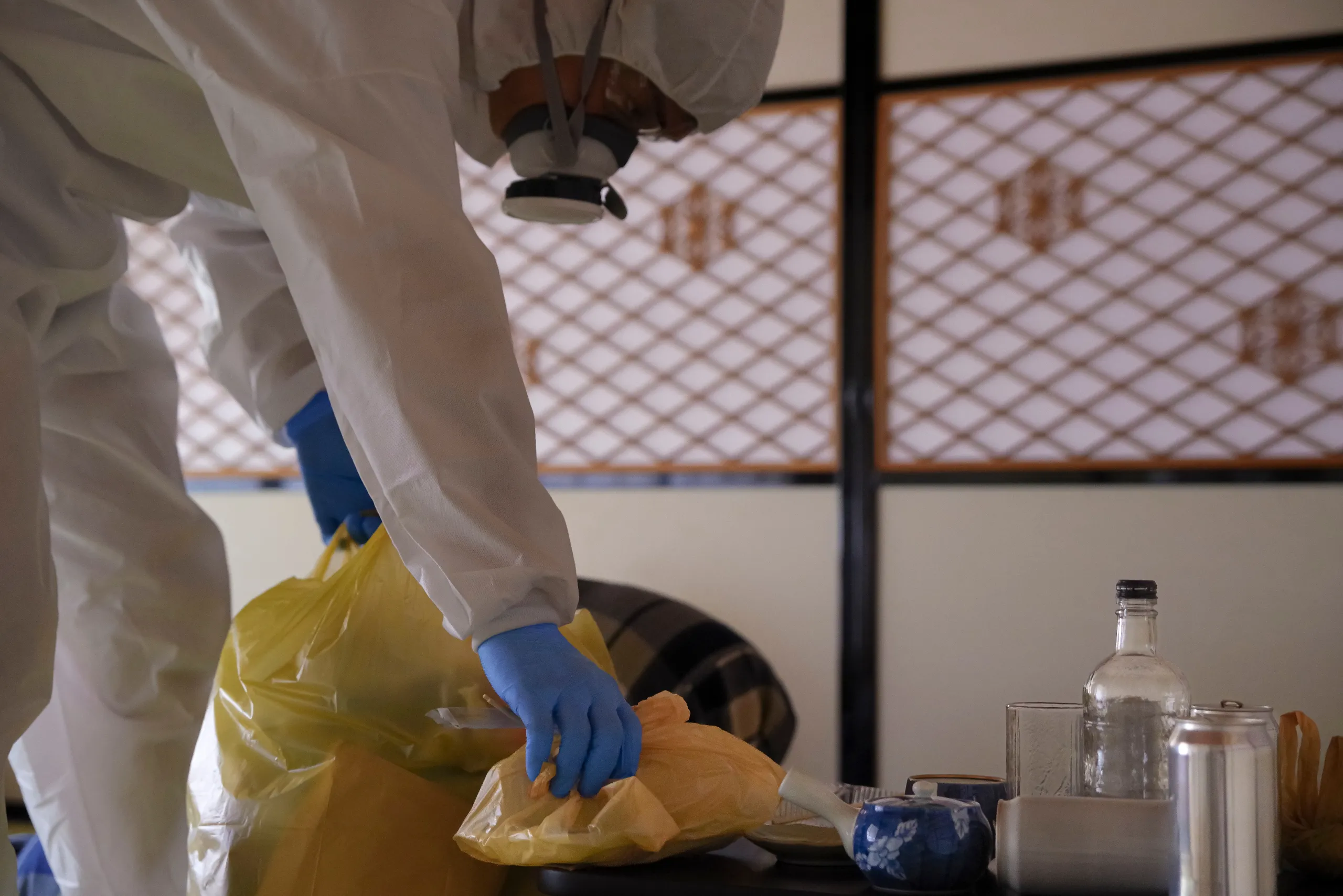 Person in einem Schutzanzug, wie sie dabei ist, eine Wohnung zu entrümpeln.