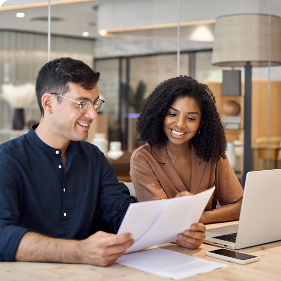 A bank marketing team reviewing rate information together at a laptop, representing Leadfusion RateSync automated rate updates