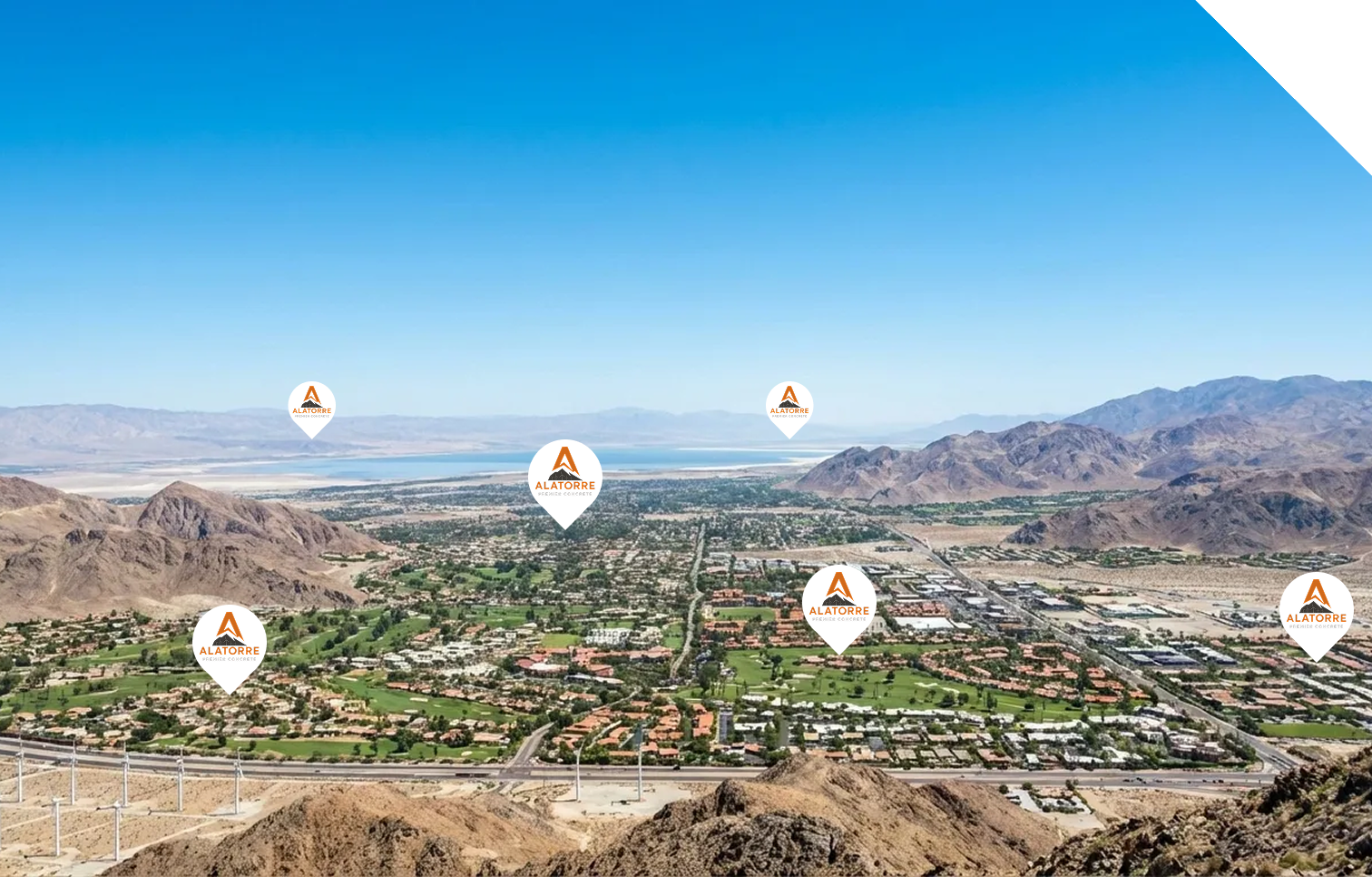 Aerial view of a desert city landscape with mountains in the background, marked with several pin icons featuring the Alatorre Premier Concrete logo.