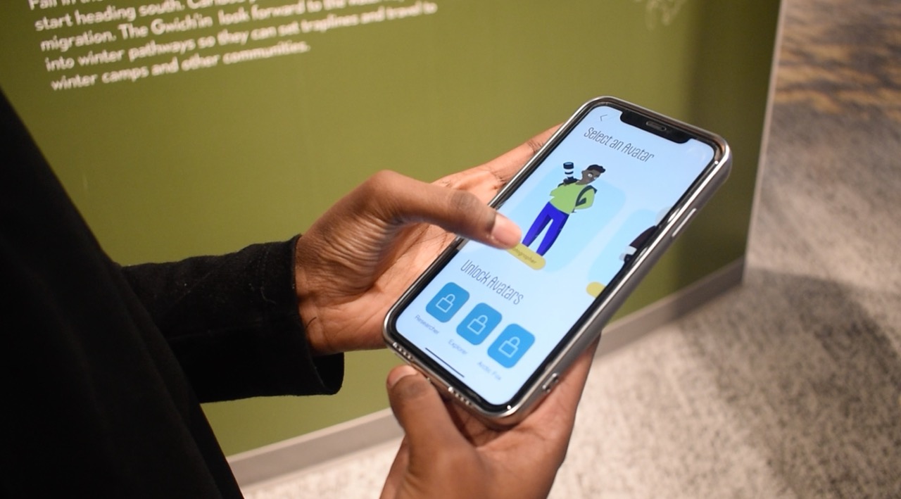 Person holding a smartphone displaying a screen to select and unlock avatars in an app.