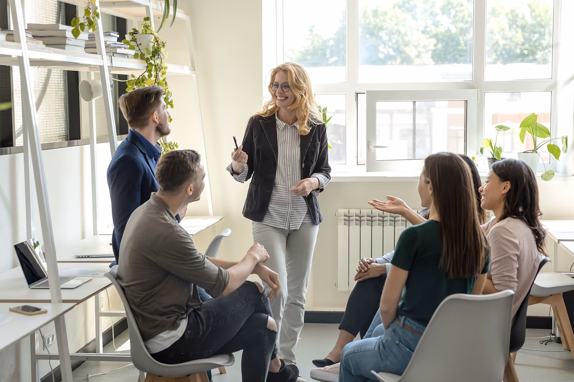 Teammeeting mit Führungskraft und Mitarbeitenden im Büro