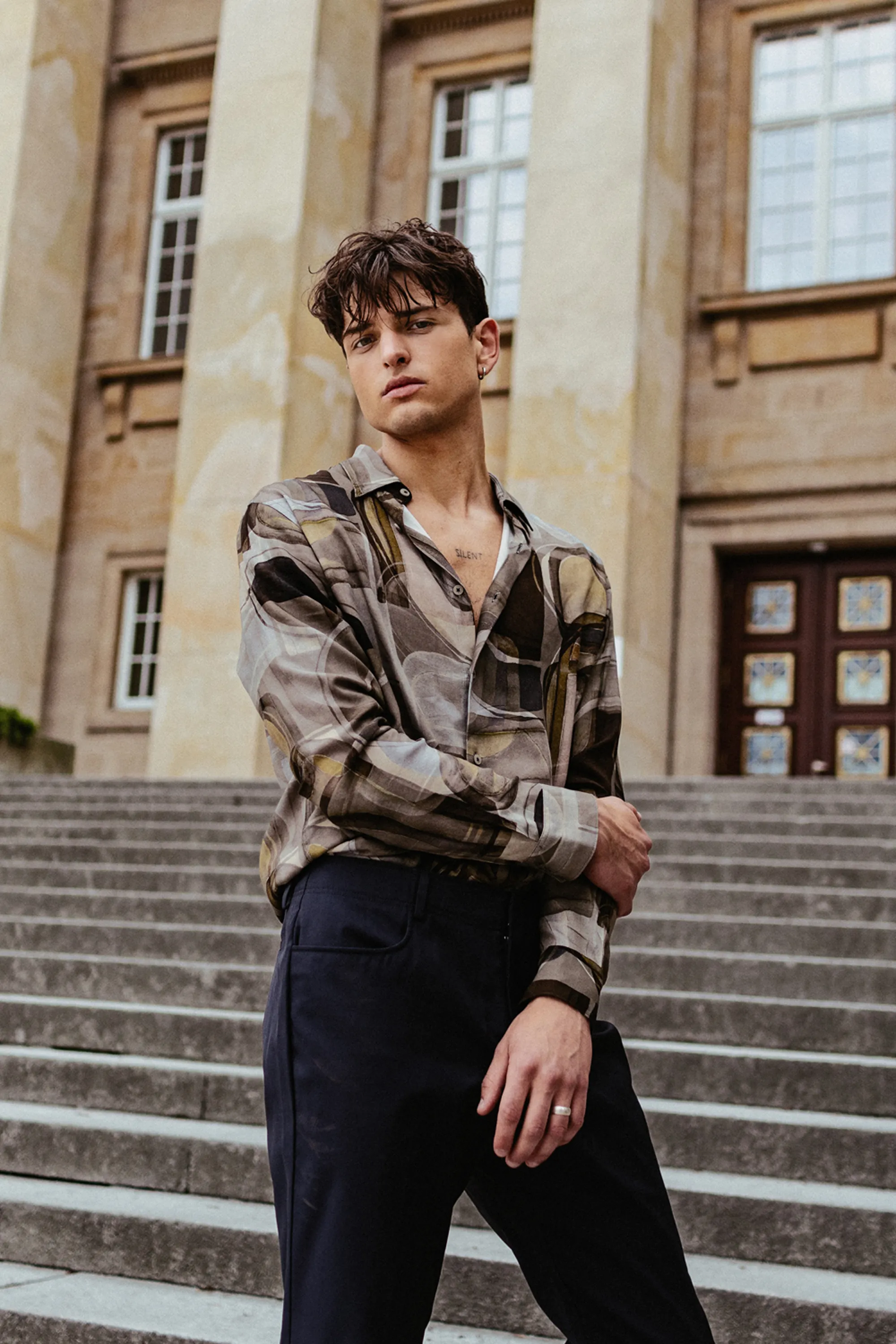 Męska sesja lifestyle w plenerze – model na schodach historycznego budynku we Wrocławiu.