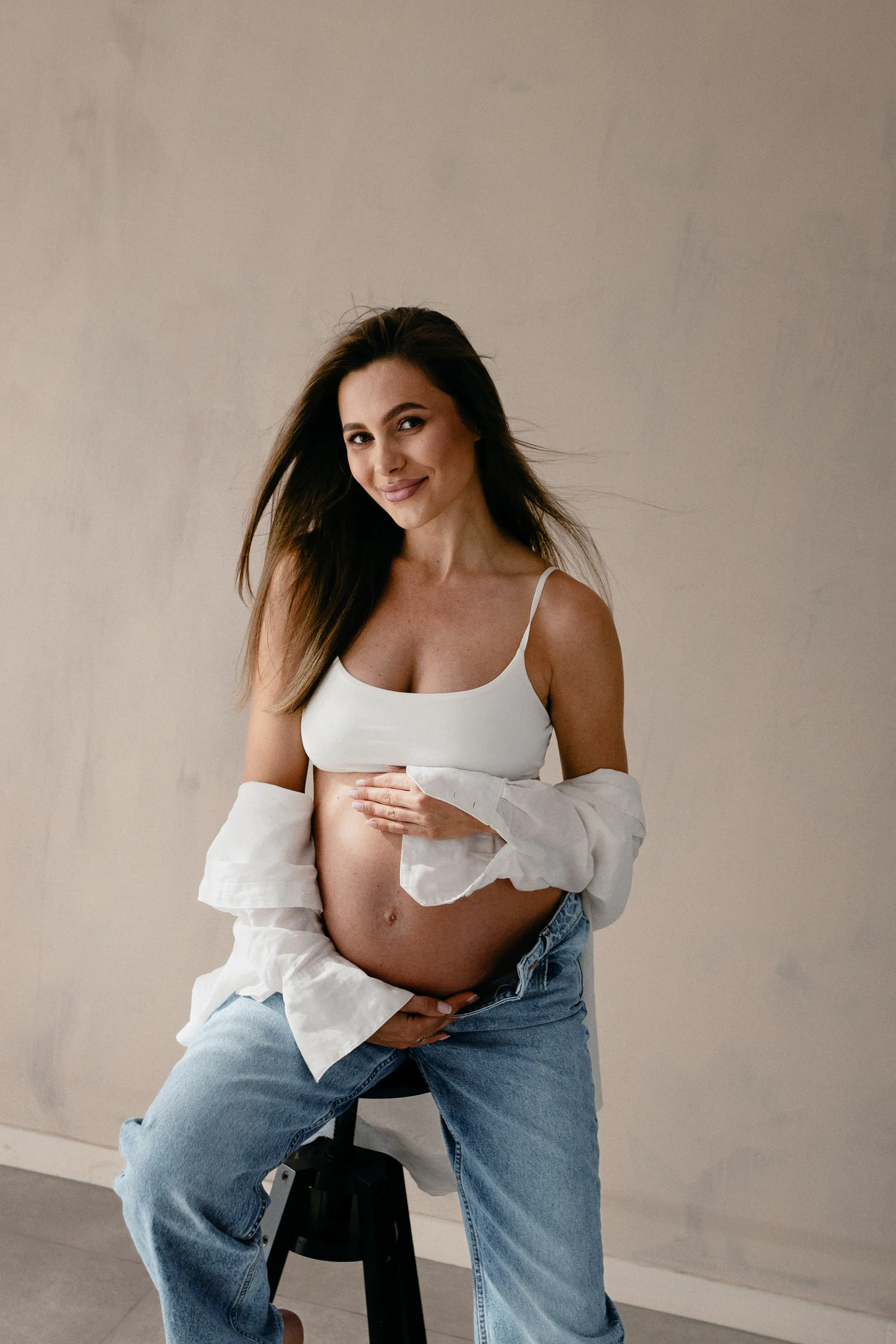 Naturalna sesja brzuszkowa typu lifestyle – portret uśmiechniętej kobiety w ciąży, studio Opole.