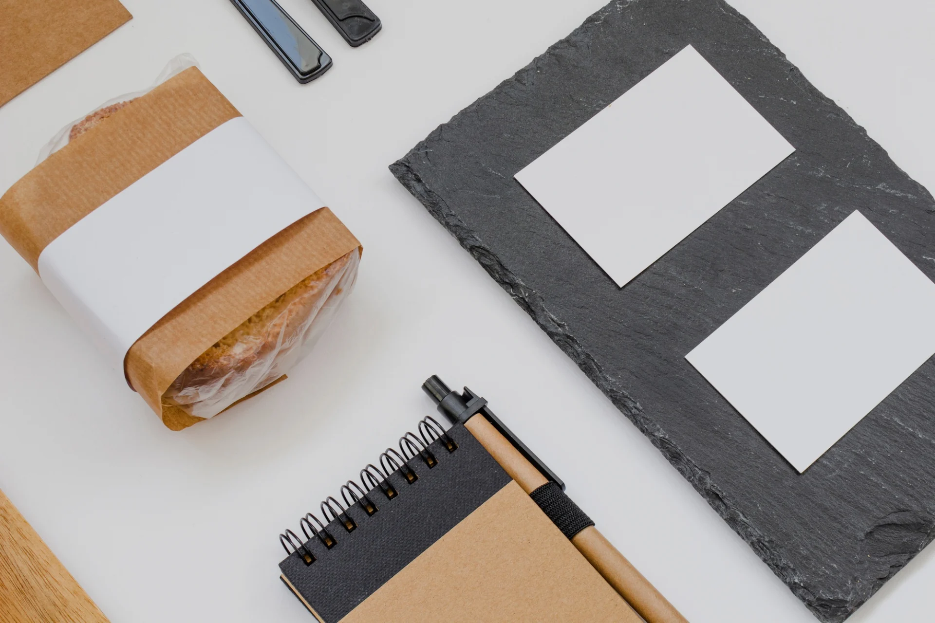 Neutrálne papierové prvky a rozloženie materiálov znázorňujúce systematické nastavovanie identity značky.