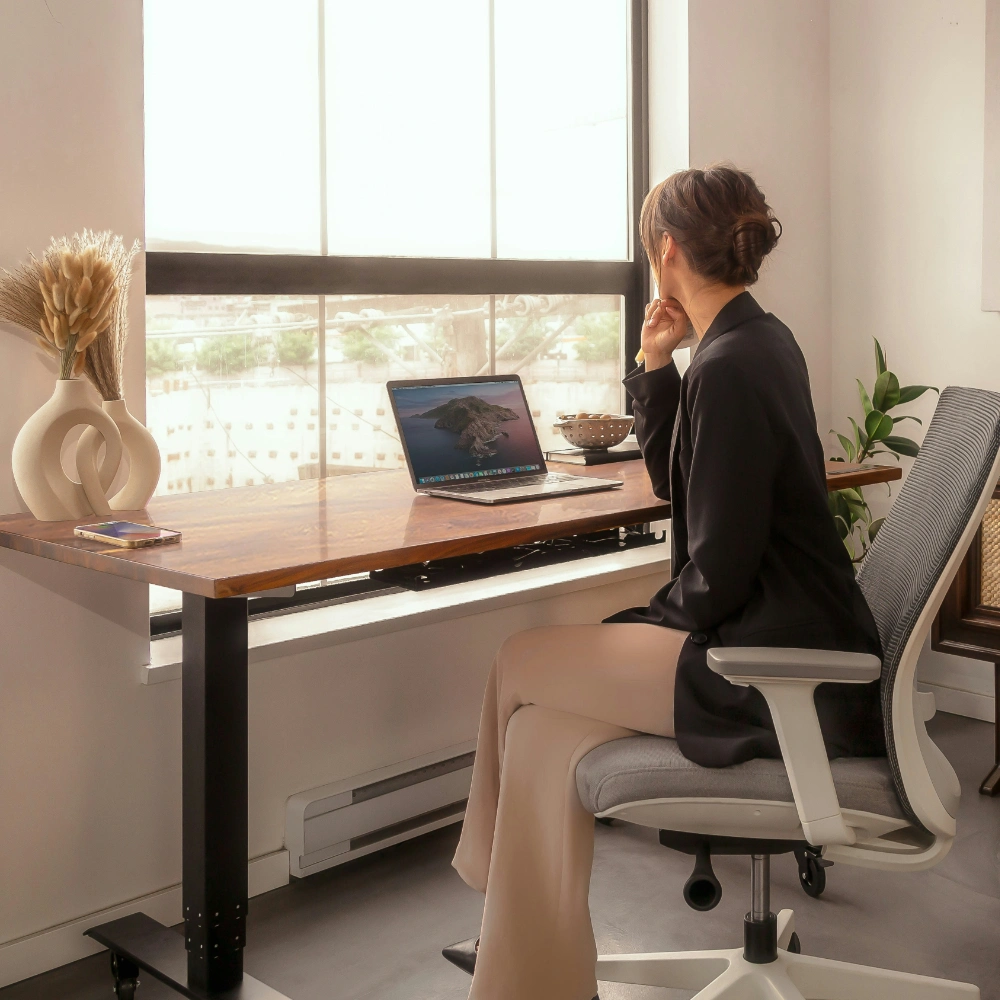 Osoba pracujúca pri pracovnom stole s notebookom v svetlom kancelárskom prostredí, znázorňujúca dlhodobú spoluprácu, kontinuitu a stabilný pracovný proces.