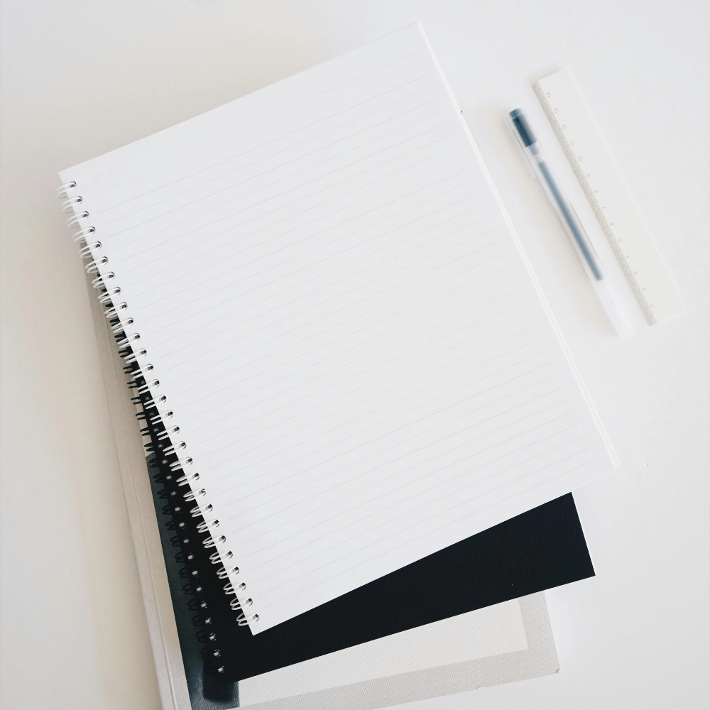 Otvorený zápisník s čistými stranami a perom na pracovnom stole, symbolizujúci jasne definovaný proces, metodiku práce a systematický prístup.