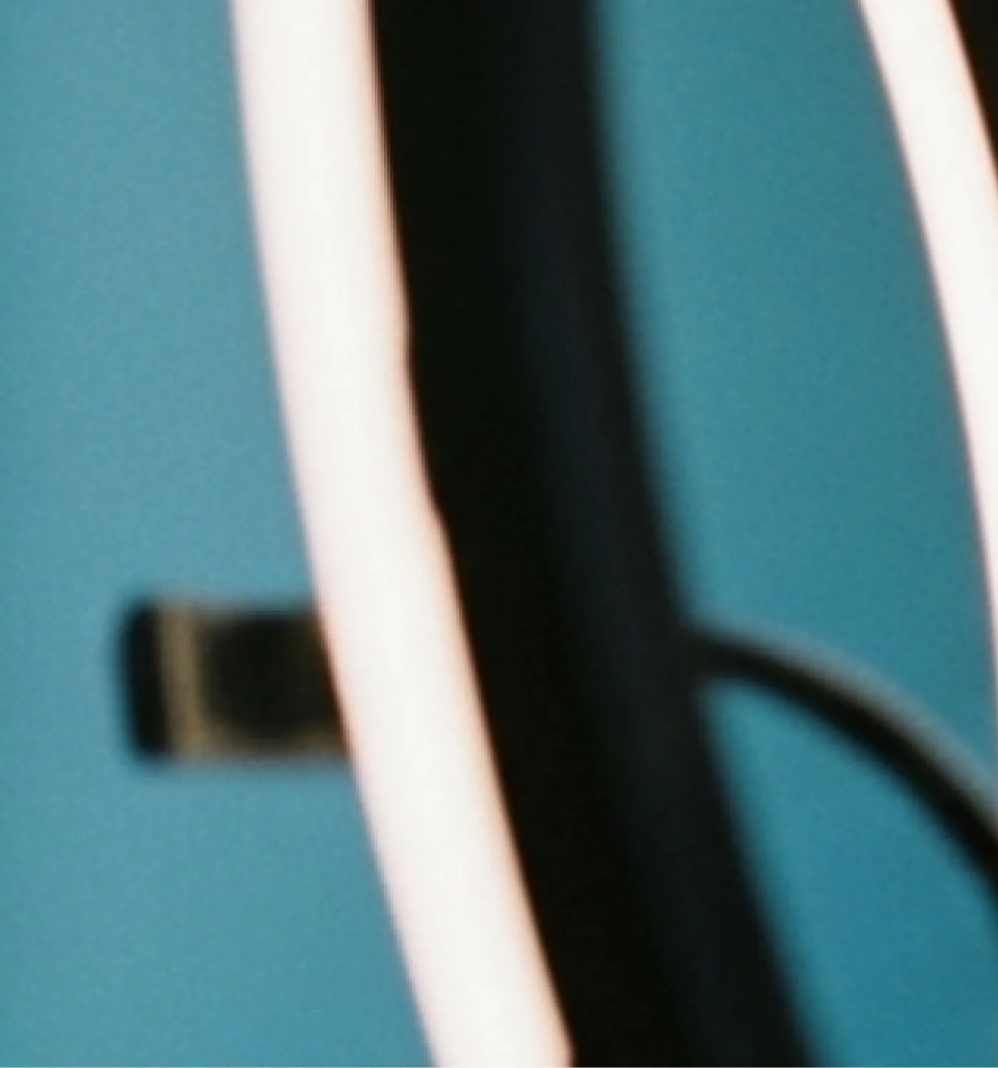 Close-up of a white and black curved object against a blue background.