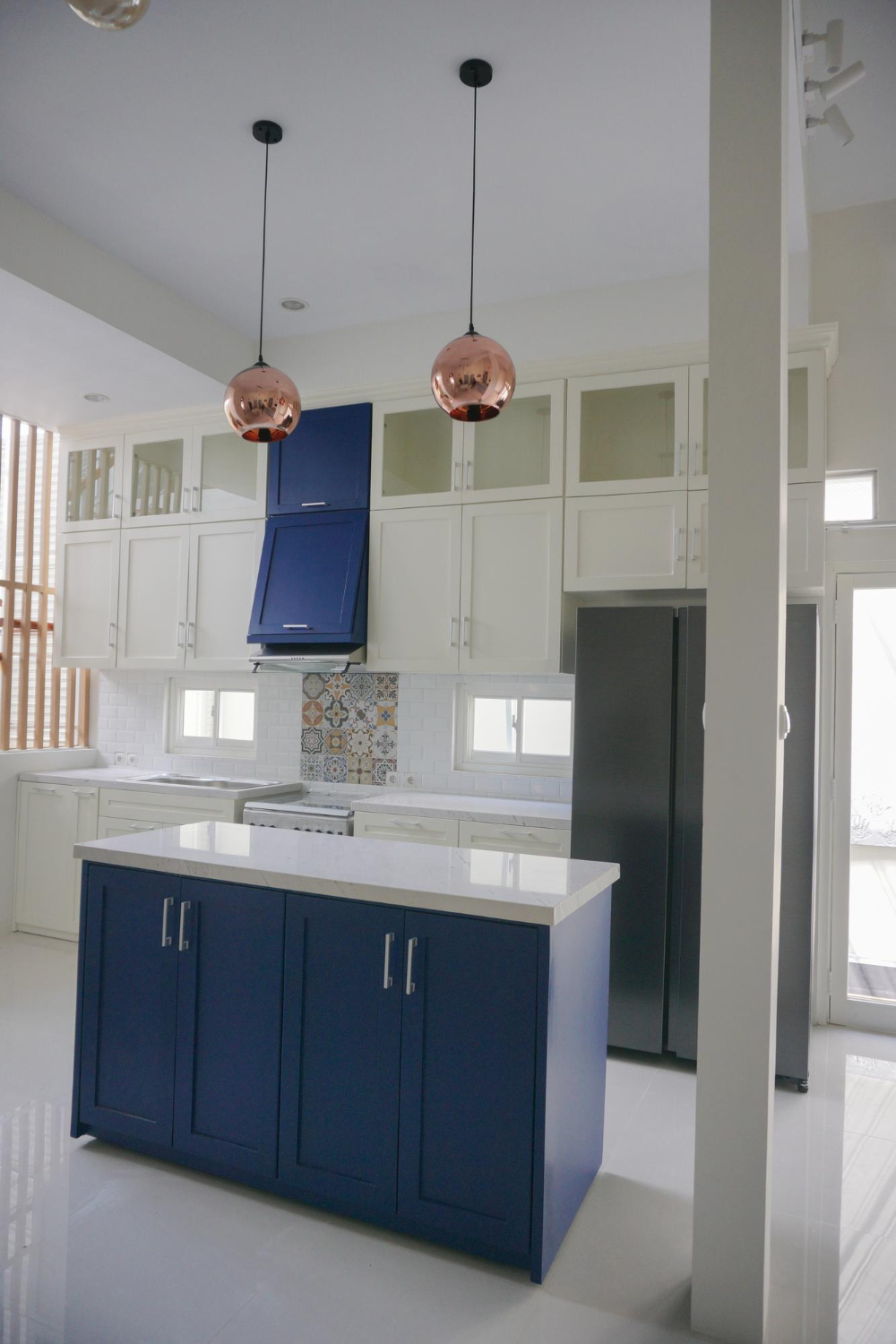 Modern two-tone kitchen design with navy blue island and white shaker cabinets in Clearwater, Florida web Gonzo Interiors.