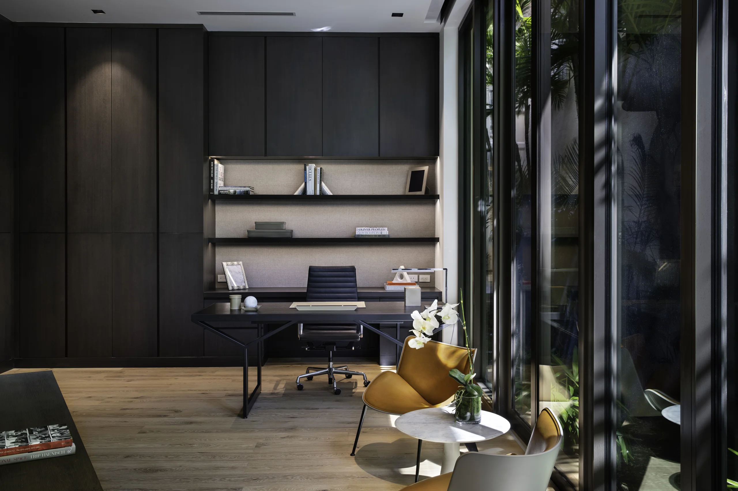 Home office with dark wood built-ins, floating shelves, and a leather task chair at a black steel-frame desk, Star Island Waterfront project by Dunagan Design.
