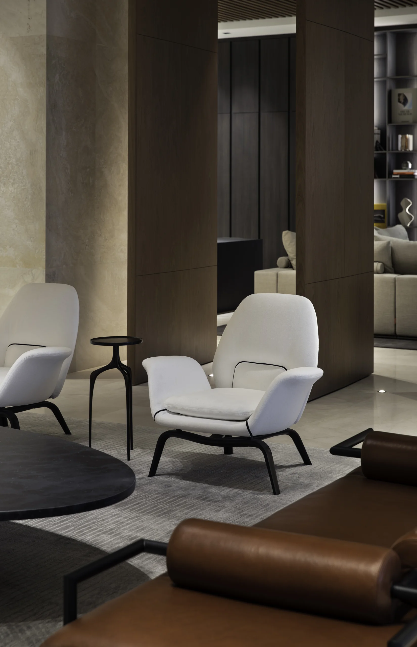 Living area seating with sculptural white lounge chairs and a brown leather daybed, Star Island Waterfront project by Dunagan Design.