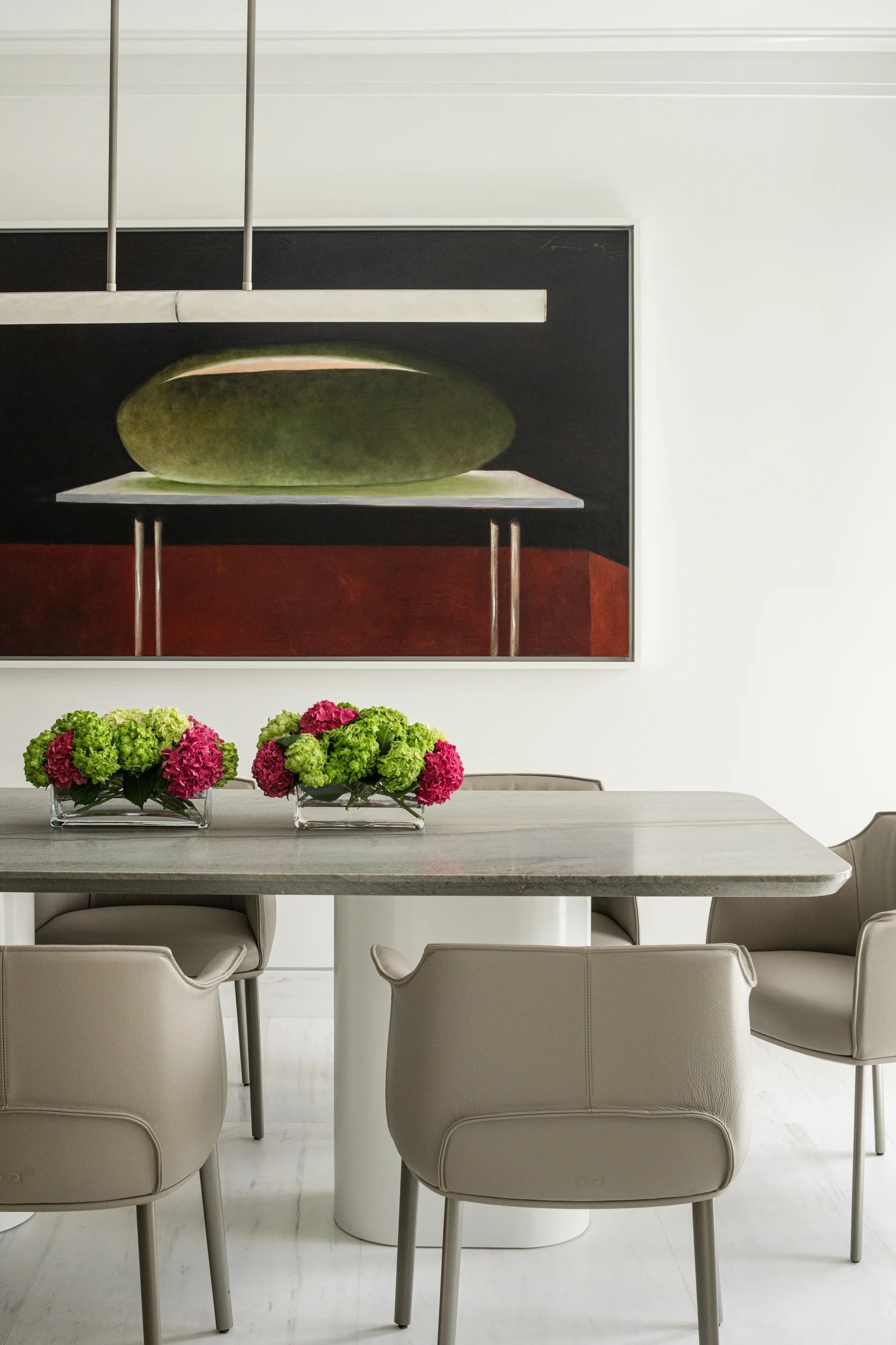 Breakfast dining area with a stone table, leather chairs, and a still-life painting, Coco Plum Revival project by Dunagan Design.