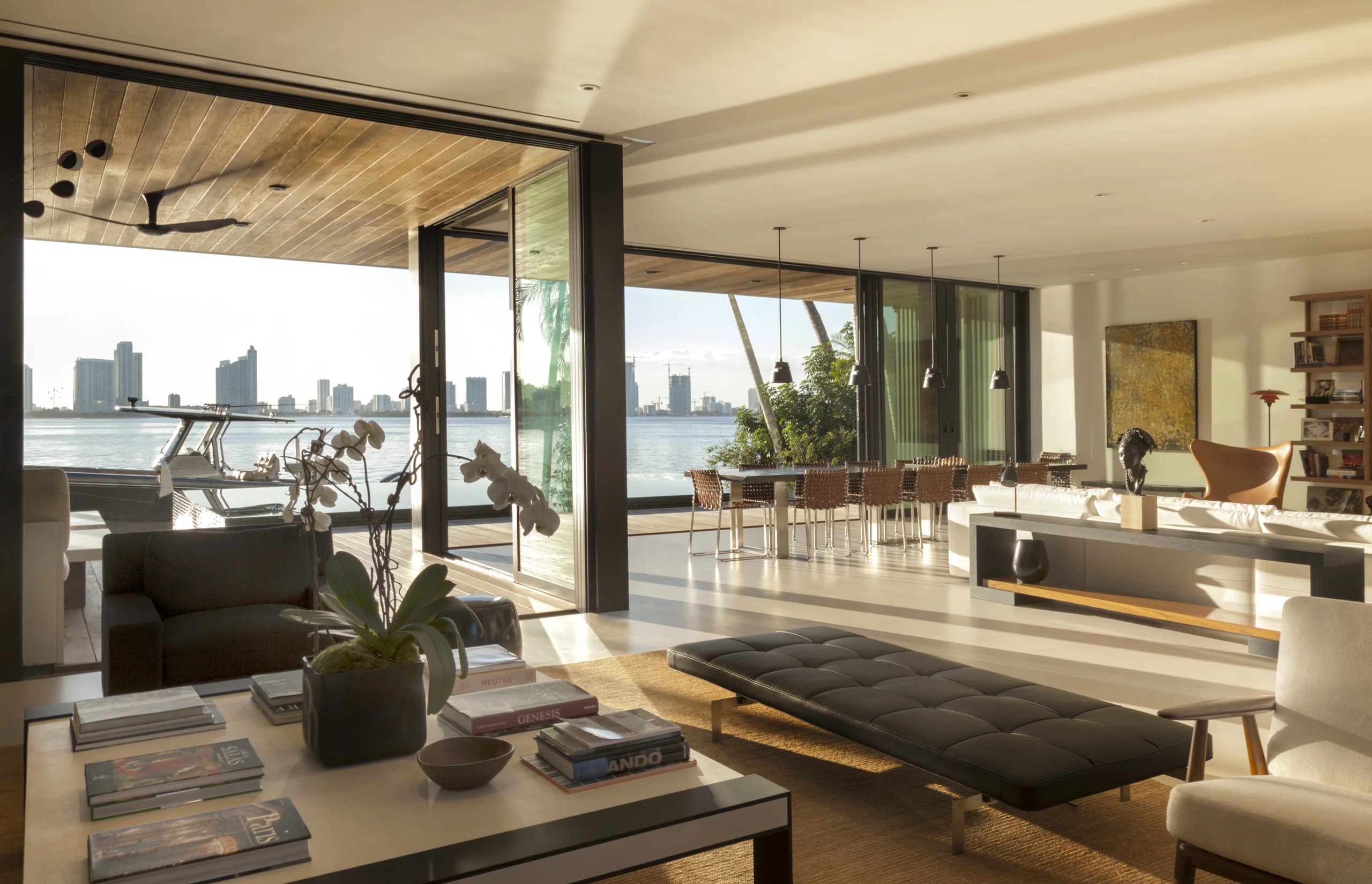 Living and dining area with mid-century leather seating and a panoramic bay and skyline view, Bayside Modern project by Dunagan Design.