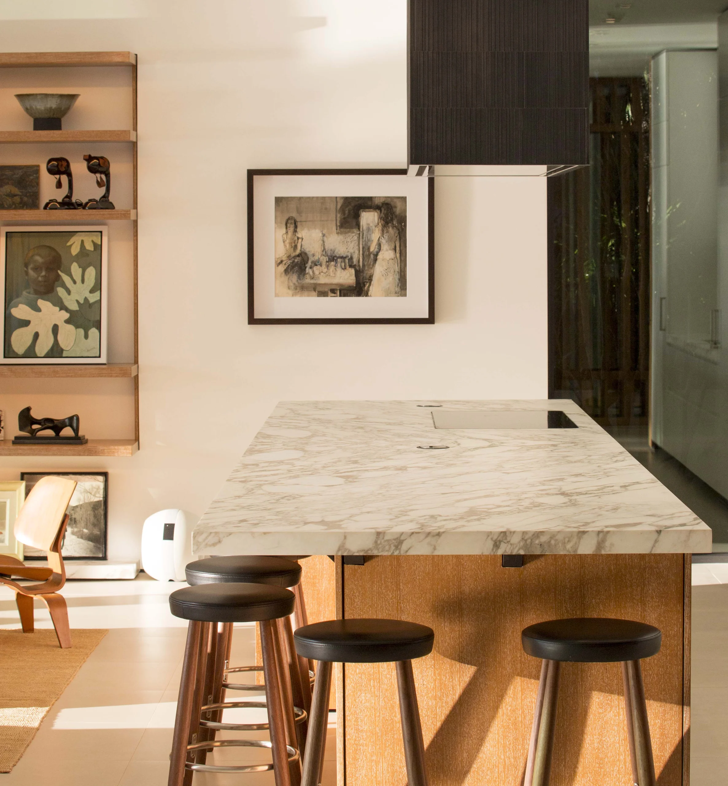 Kitchen island styled with a curated art and object collection on adjacent open shelving, Bayside Modern project by Dunagan Design.