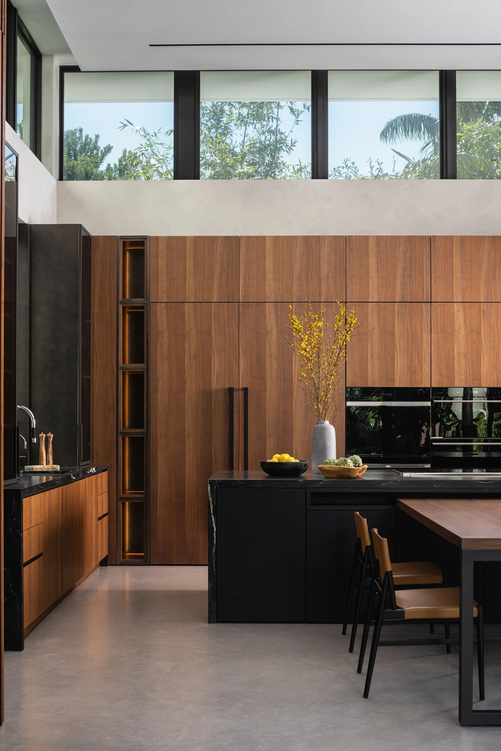 Kitchen with walnut cabinetry, backlit display niches, and clerestory windows, Spanish River Modern project by Dunagan Design.