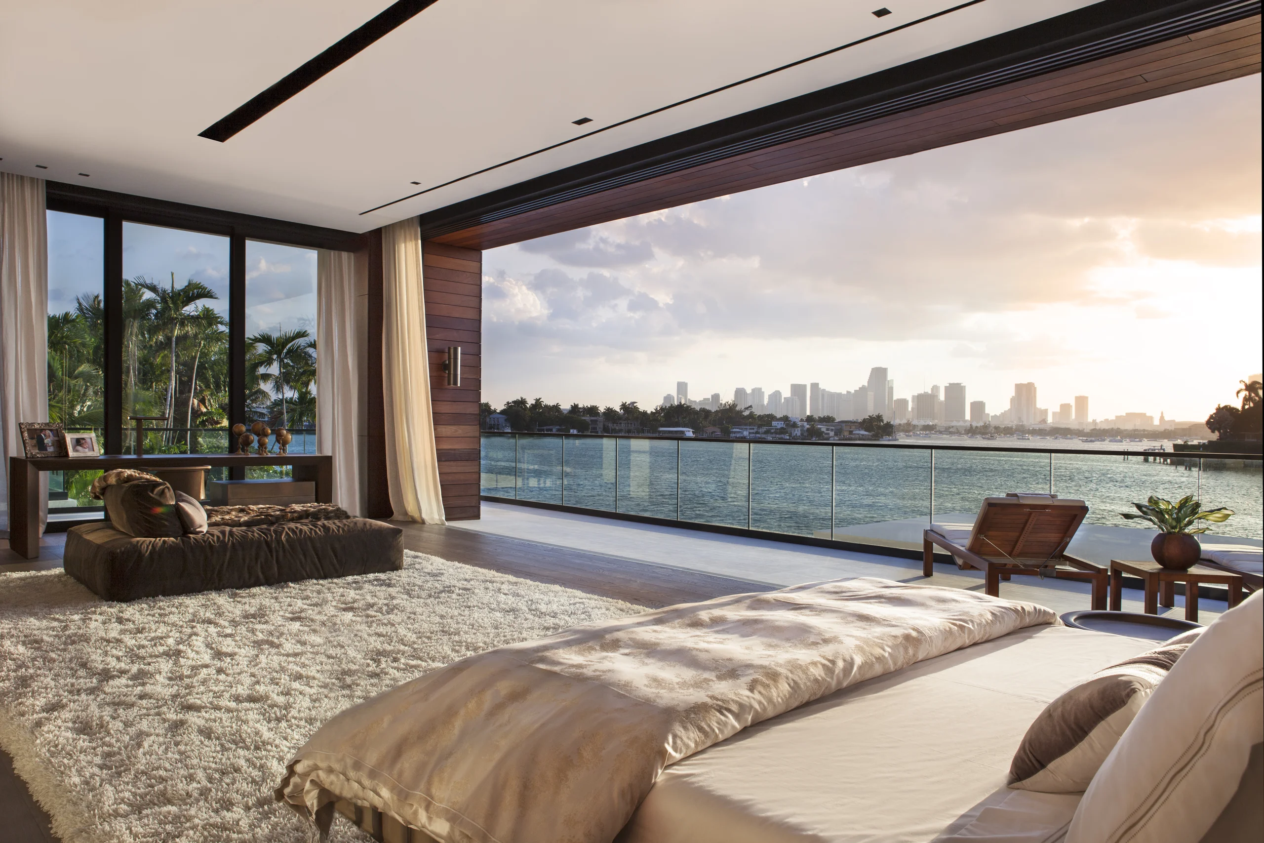 Primary bedroom opening onto a private terrace with panoramic bay and skyline views, DiLido Modern project by Dunagan Design.