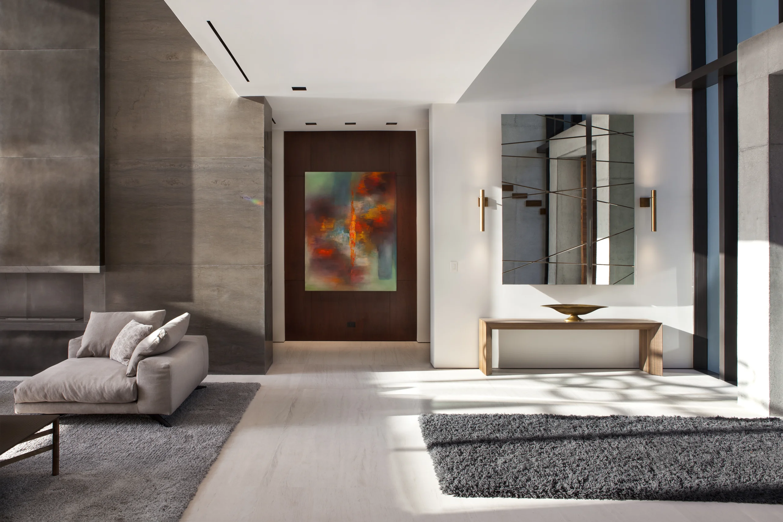 Gallery entry with a large-scale abstract painting and a geometric brass mirror, DiLido Modern project by Dunagan Design.