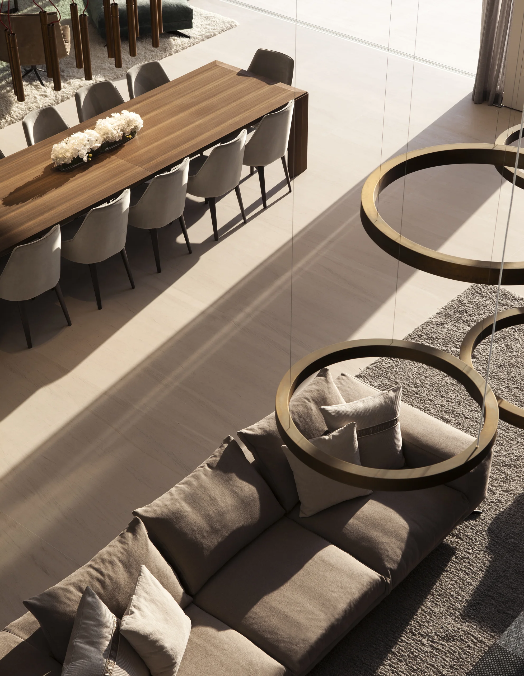 Aerial view of the dining and living areas beneath a brass ring chandelier, DiLido Modern project by Dunagan Design.