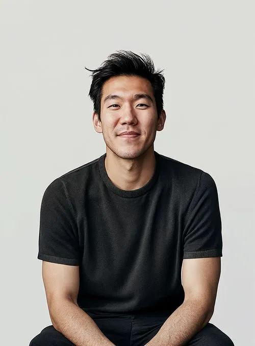 A man sitting on a stool in a black shirt.
