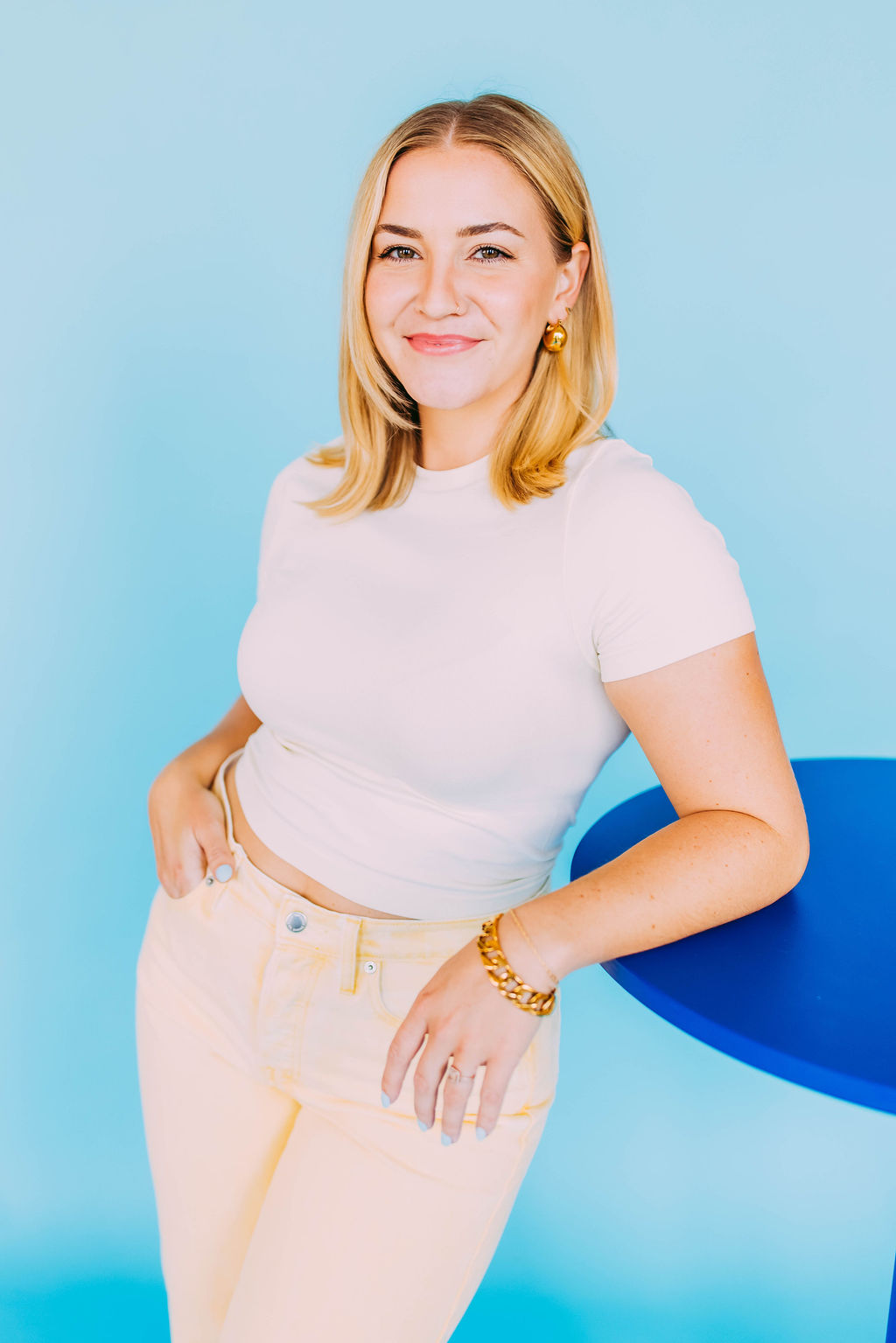Portrait of Allie Laing-Rapp smiling against a blue background