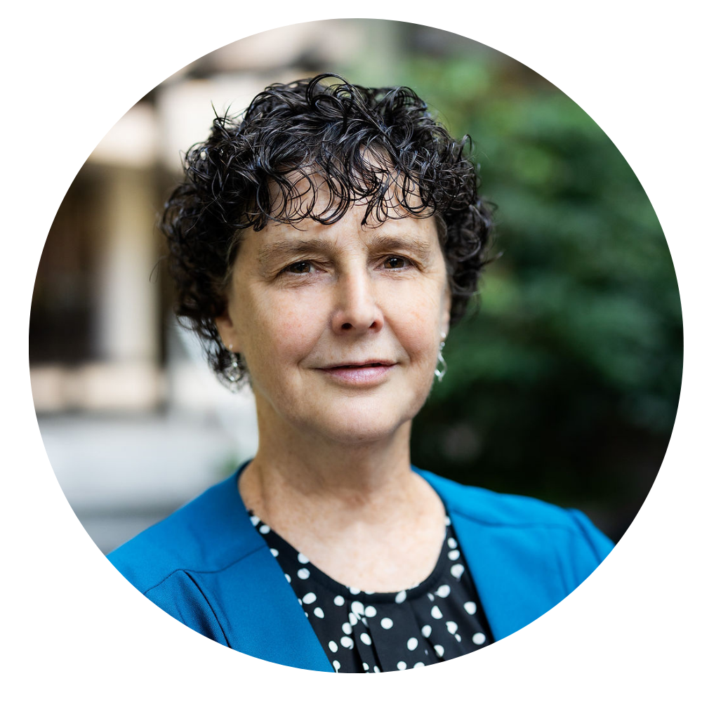 Chaney Cruze, Sr. Director of Youth Adult Engagement Photo shows a close-up portrait of a woman with short curly dark hair and light skin, wearing a blue blazer over a black shirt with white polka dots, looking directly at the camera with a neutral expression, with a softly blurred outdoor background.