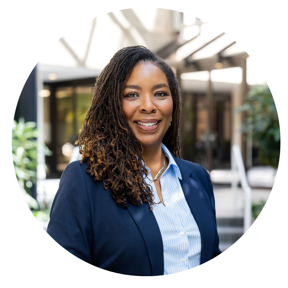 Pamela Madison CEO, Photo shows Smiling woman with long curly hair wearing a blue blazer over a light blue striped shirt in a bright office setting.