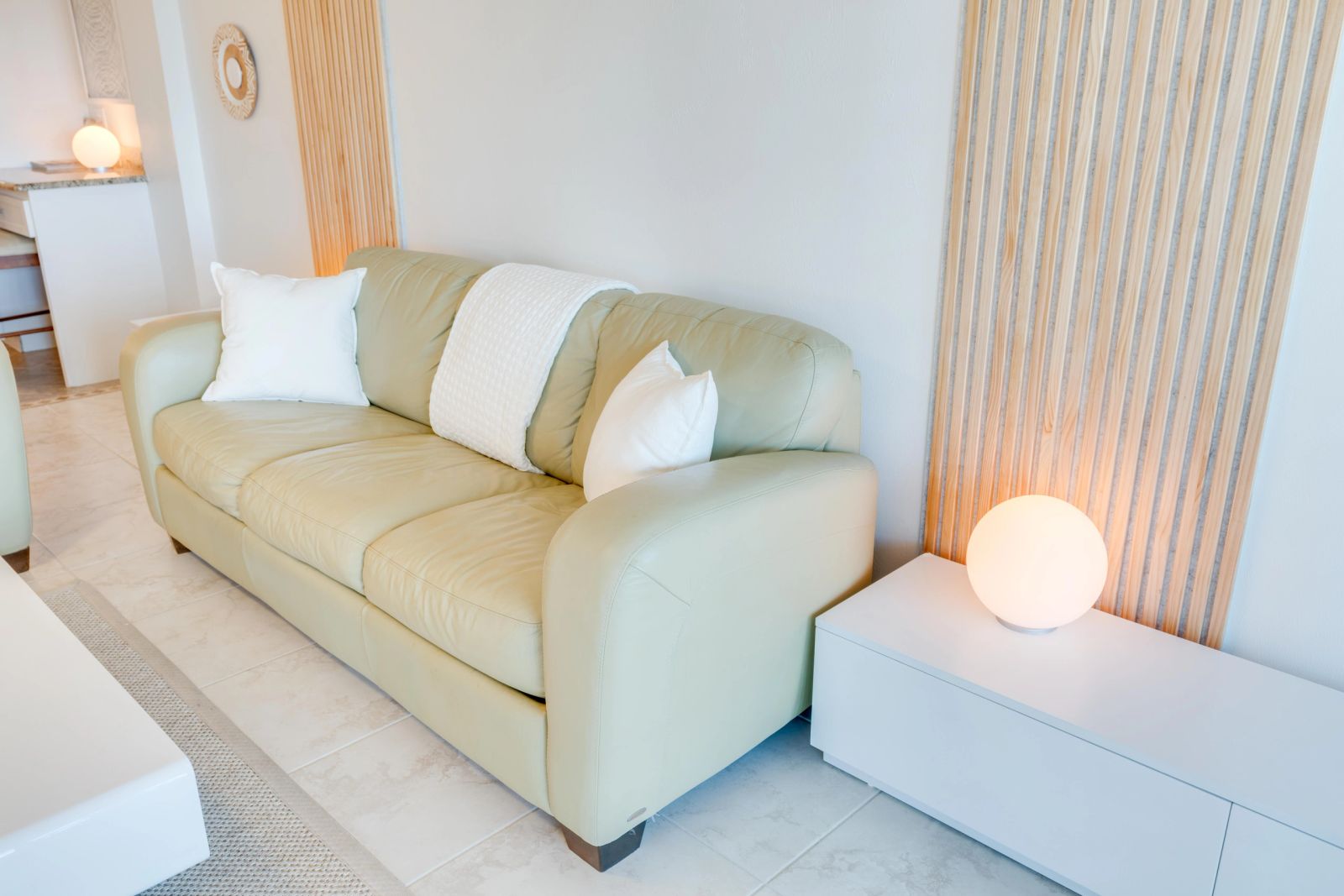 Pale green sofa beside a glowing table lamp