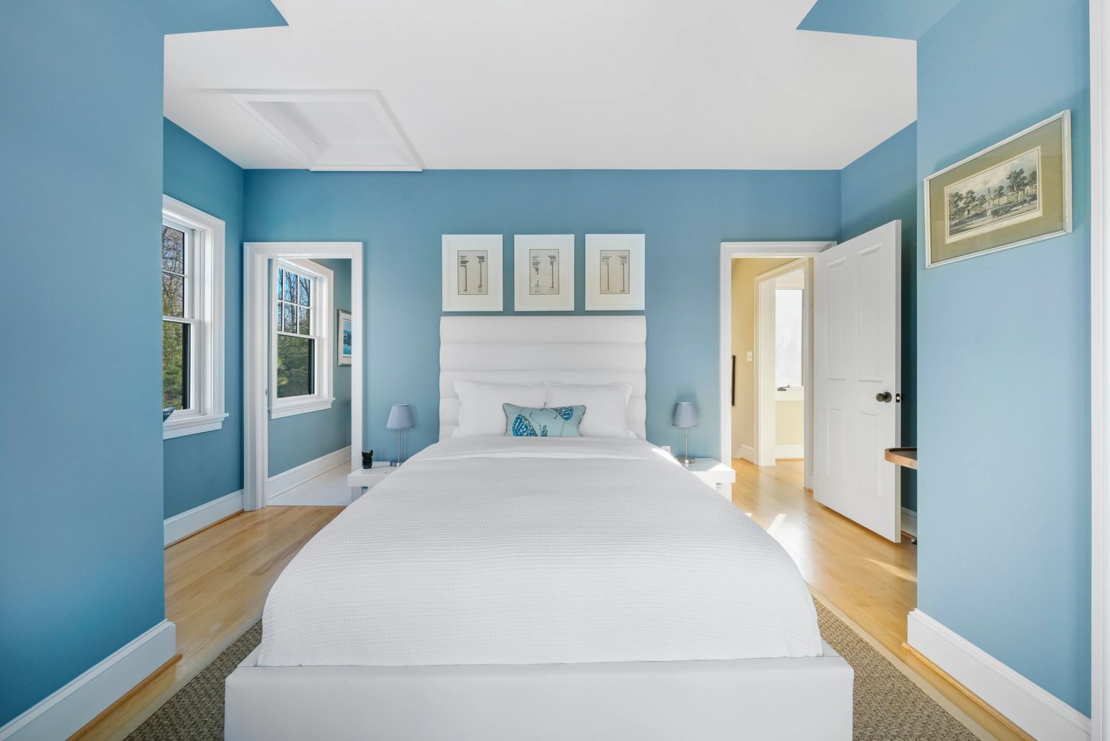 Bedroom with blue walls and a white bed