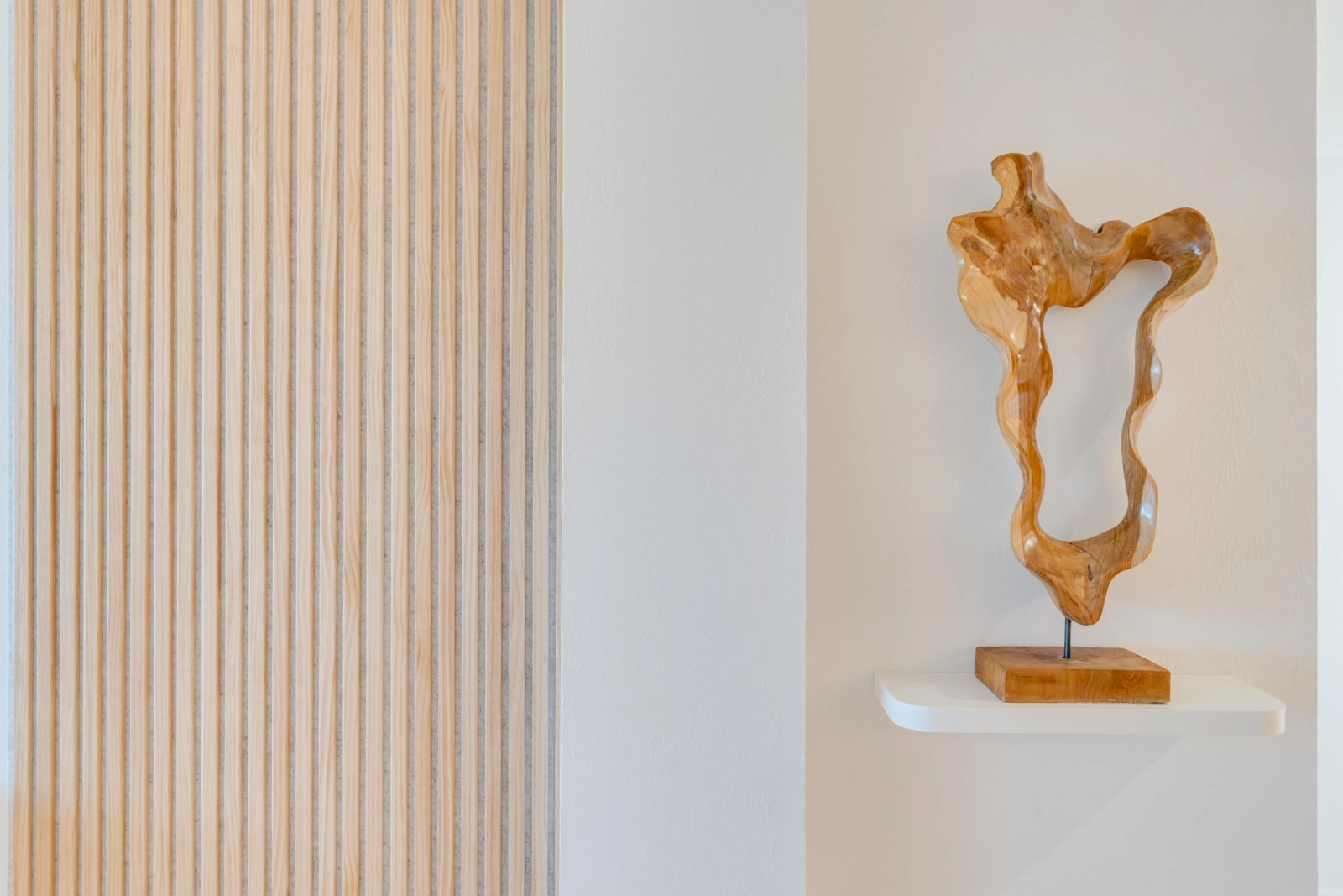 Sculptural artwork mounted against timber panelling