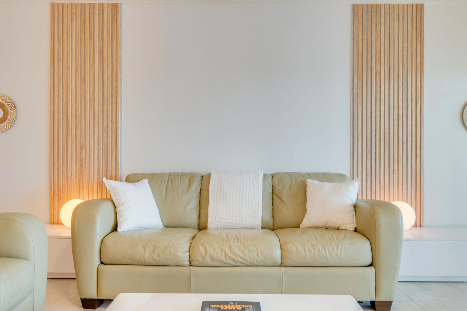 Pale green sofa framed by vertical timber panels