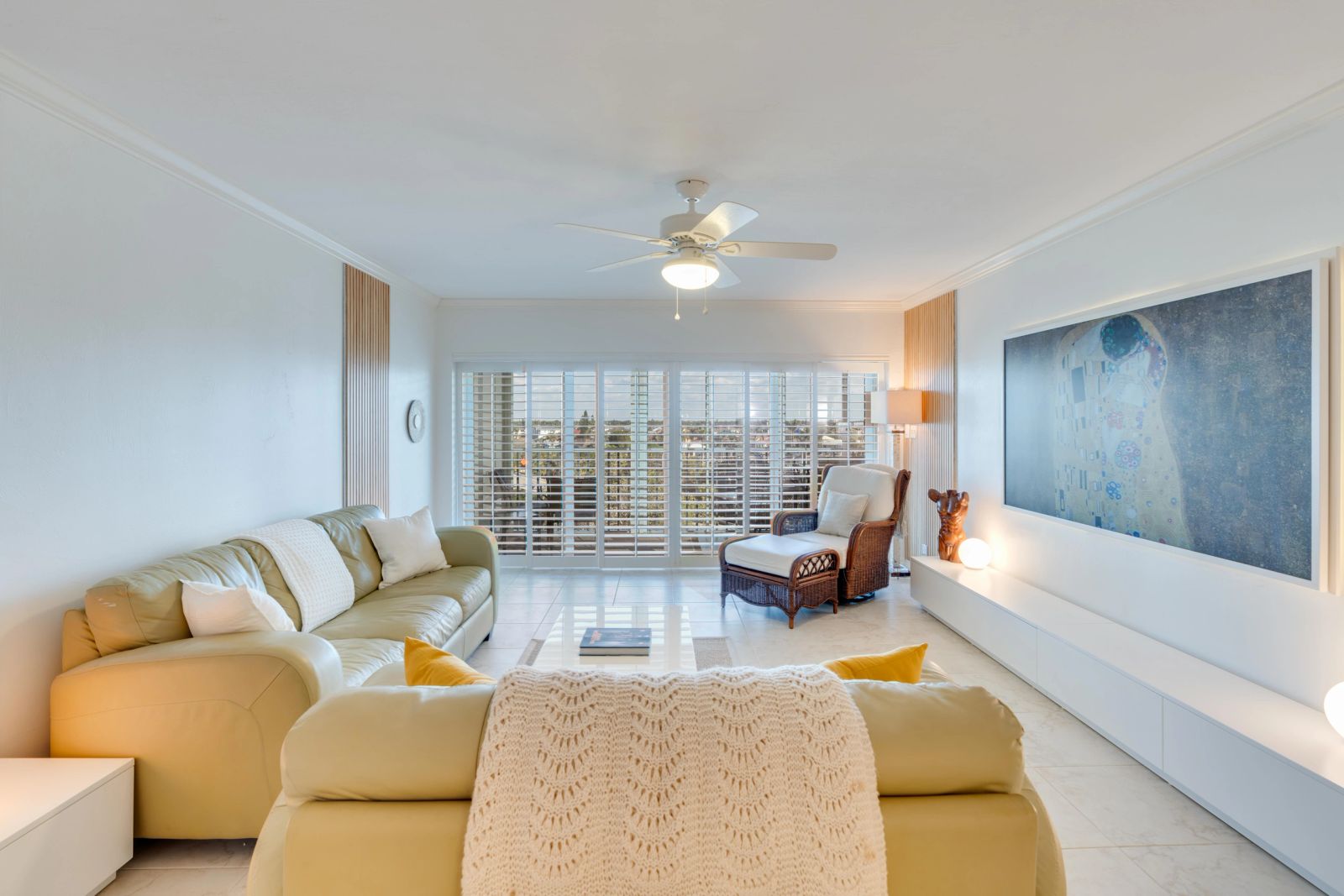 Open-plan living room with green seating and a wall-mounted screen