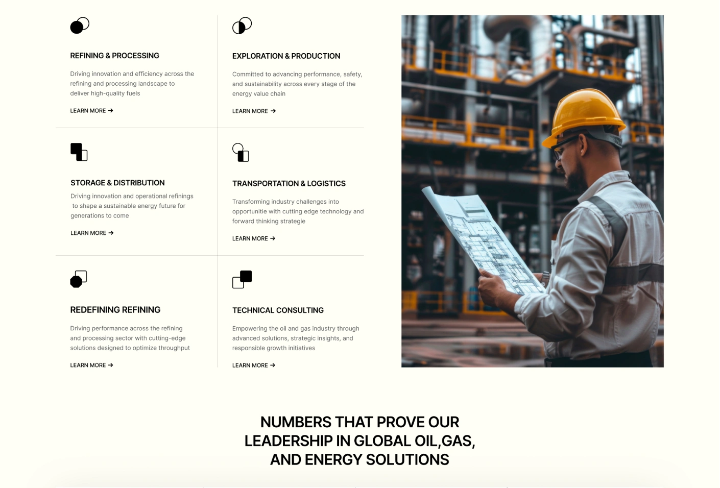 Industrial worker wearing a yellow hard hat and safety glasses reviewing blueprints inside a facility with metal structures and pipes.