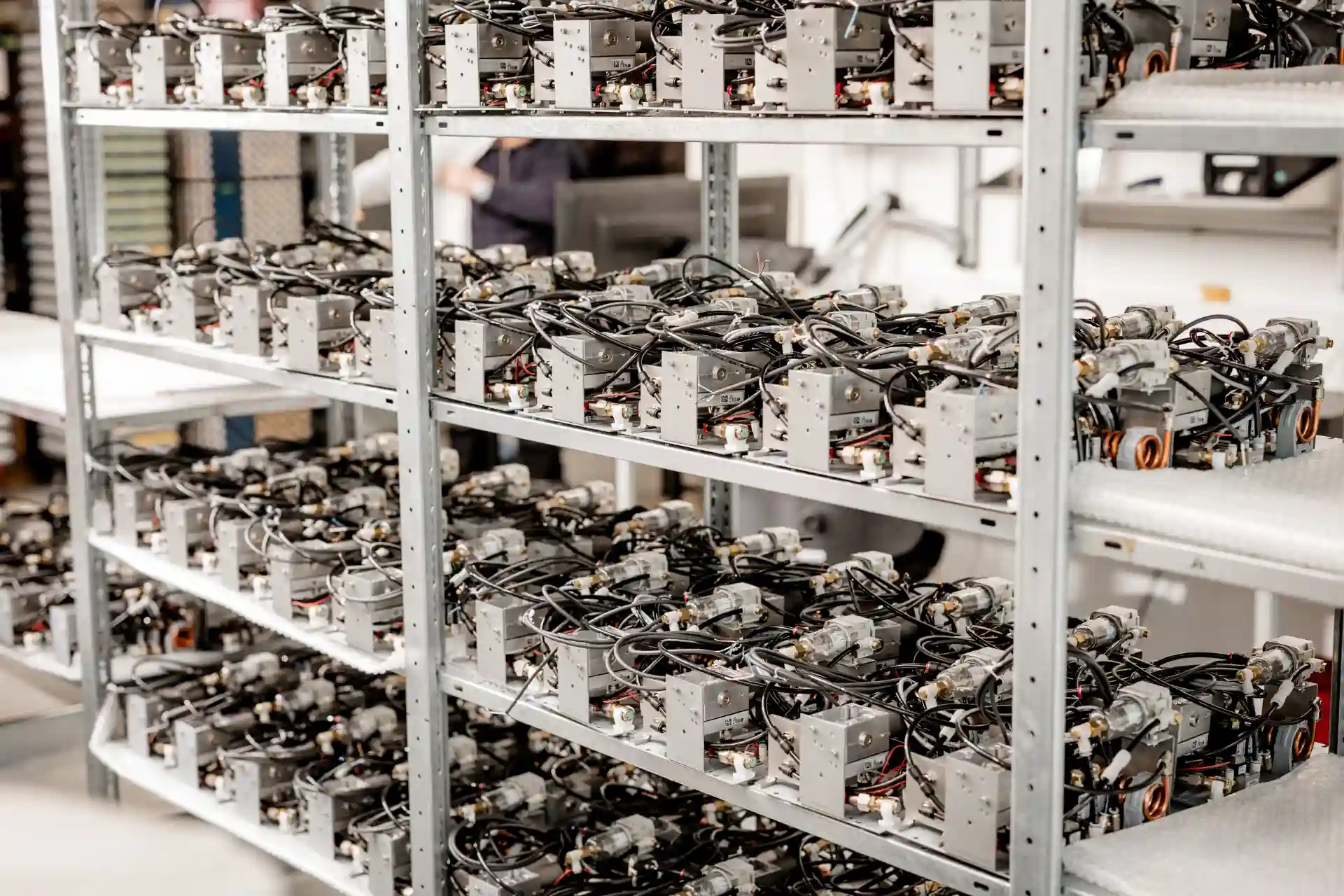 Nahaufnahme von mehreren kleinen, weißen und goldfarbenen industriellen Luftfiltern oder Reglern, die in zwei Reihen auf einer weißen Luftpolsterfolie angeordnet sind.