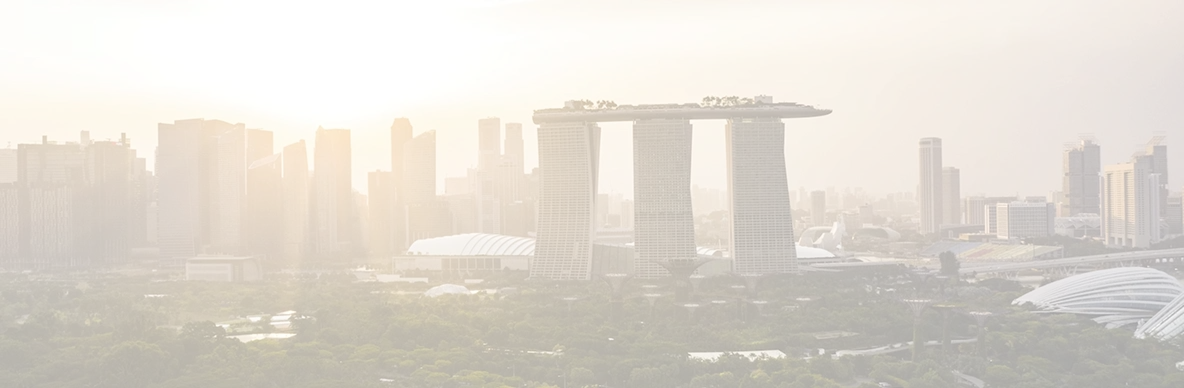 Sunset view of Marina Bay Sands hotel and surrounding skyscrapers in Singapore with lush greenery in the foreground.