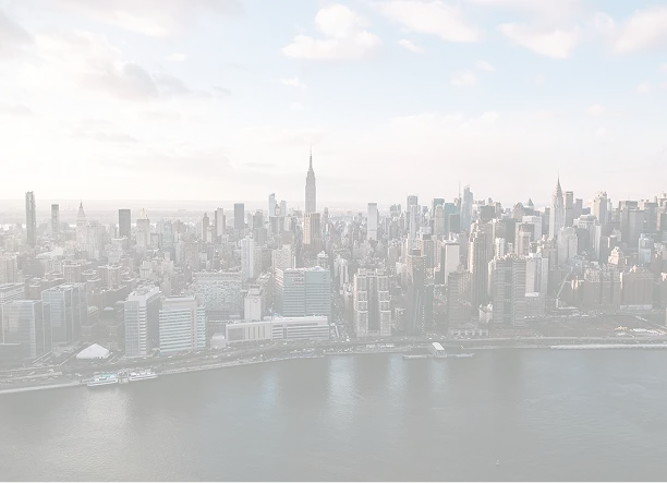 Panoramic view of New York City skyline with the Empire State Building at center and river in foreground under a partly cloudy sky.