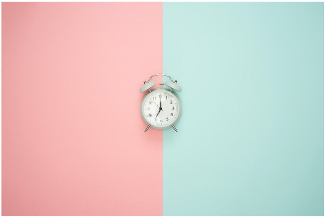 alarm clock on pink and blue background