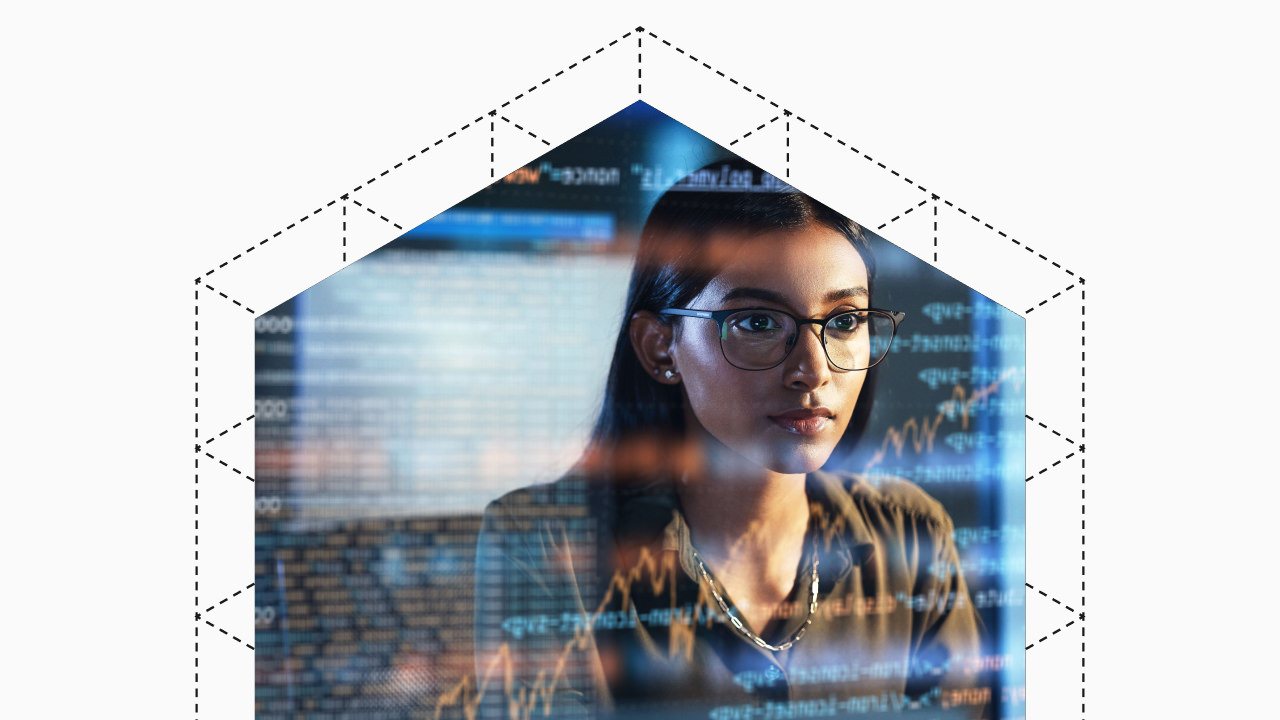 Young woman wearing glasses focused on data and code on a transparent screen in front of her.