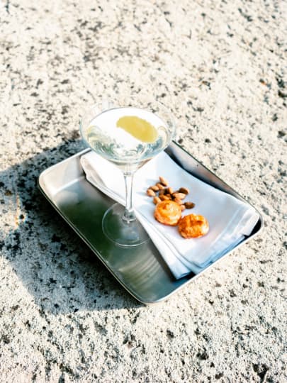 Cocktail servito con stuzzichini su una terrazza in pietra dell'Hostellerie La Briqueterie & Spa, in Champagne.